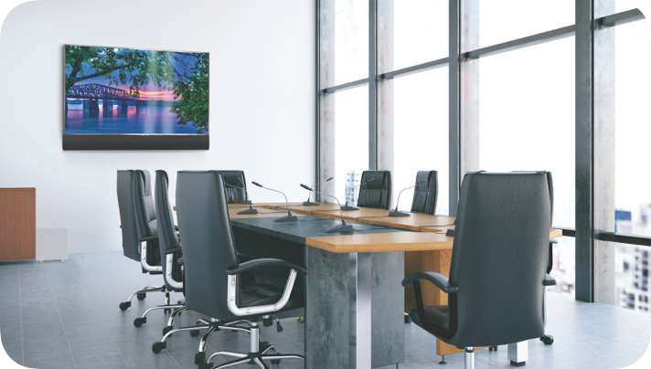Empty modern conference room with a wooden table, black leather chairs, a large window, and a wall-mounted TV.