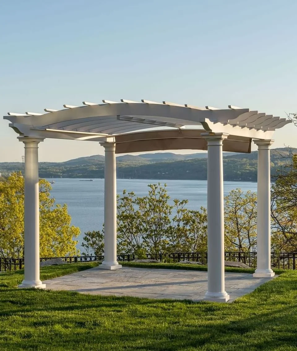 White pergola with four columns overlooking a river, with trees and hills in the background.