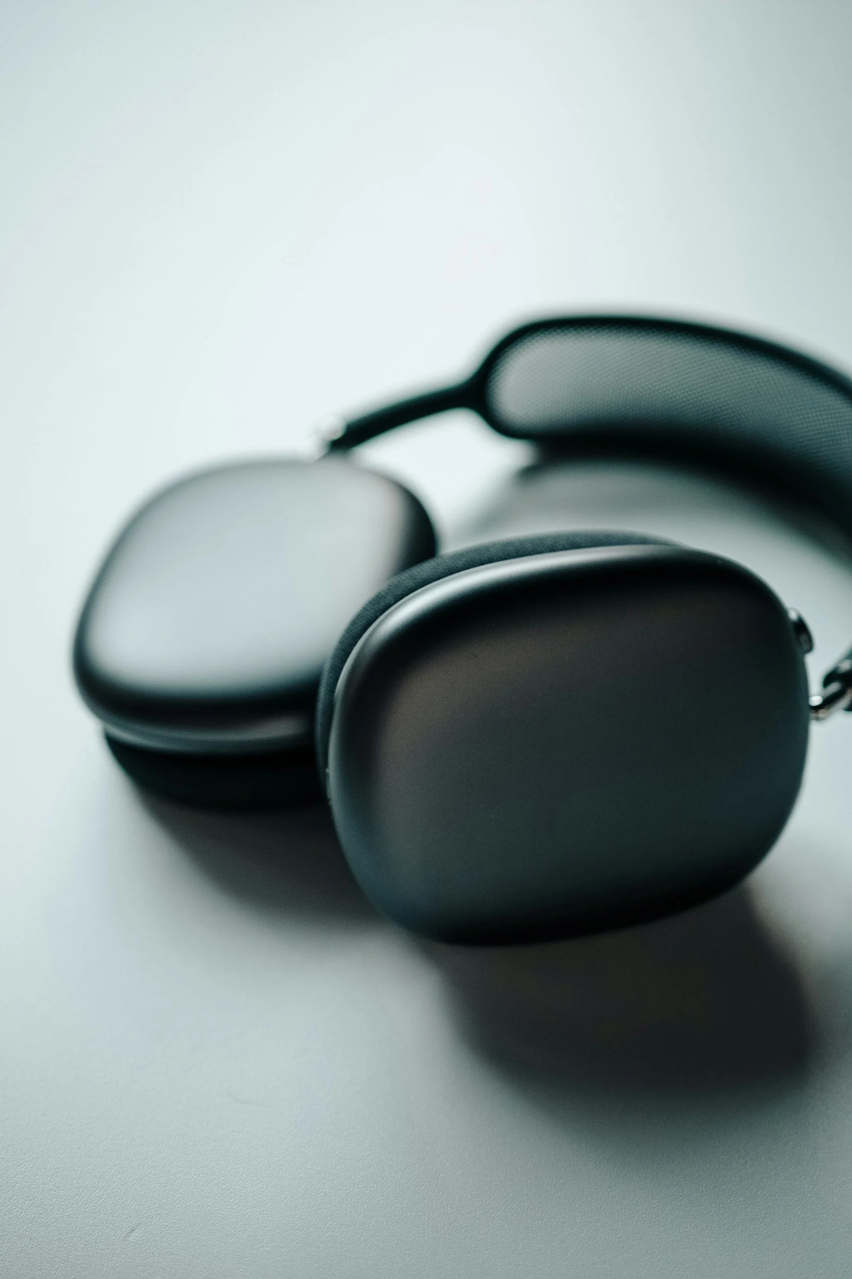 Black headphones on a light-colored surface.