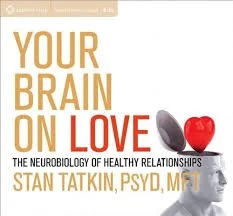 Book cover titled 'Your Brain on Love' by Stan Tatkin, PsyD, MFT, featuring a heart-shaped object and a human head silhouette.