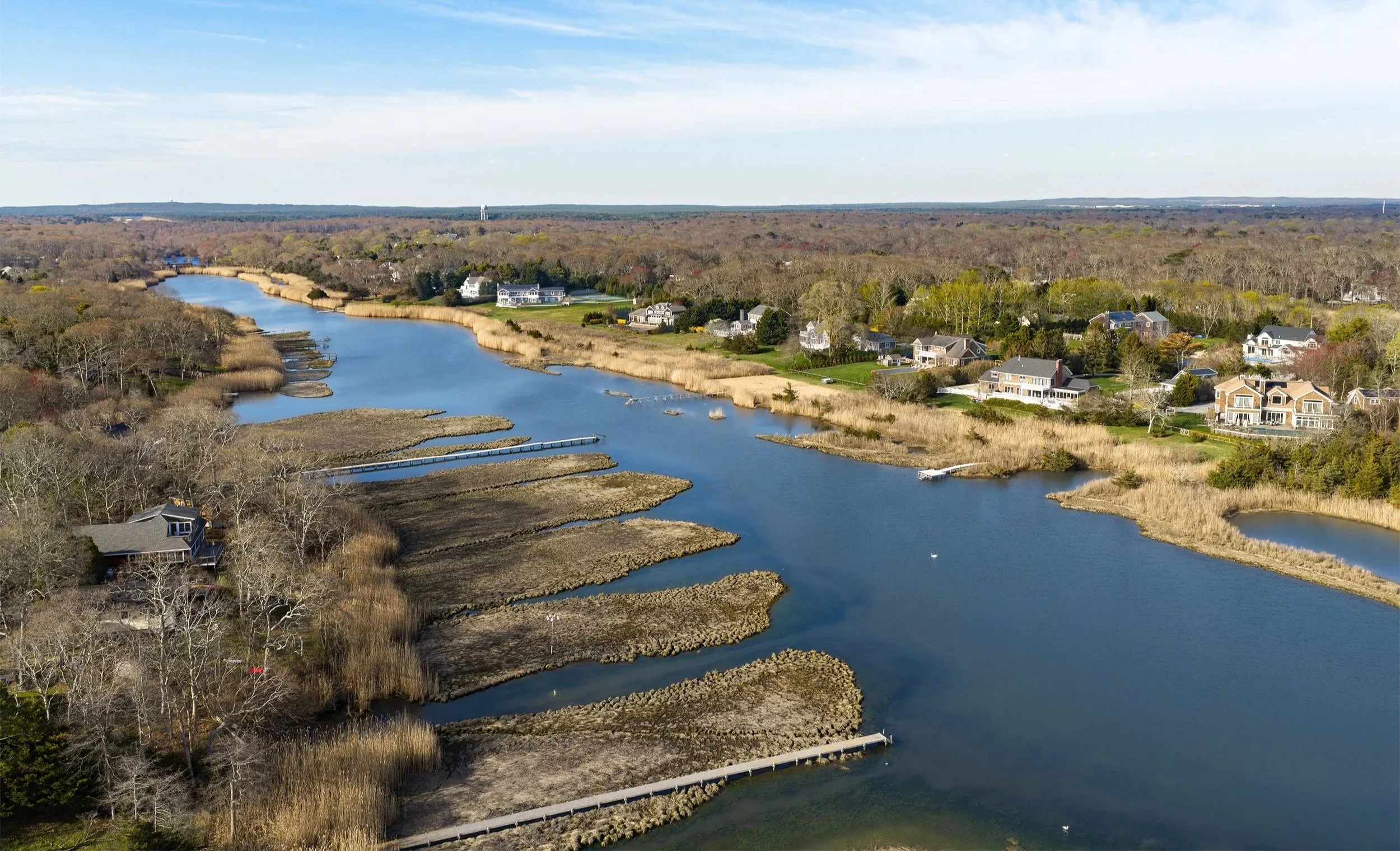  The Speonk River viewed as a connected coastal corridor, where open water, marsh edges, docks, and nearby development meet within a narrow tidal landscape. 