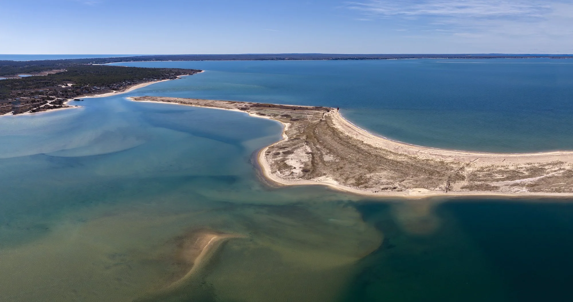   Aerial view showing the broader coastal system at Lazy Point, including shoreline curvature, tidal channels, and surrounding landscape context.  