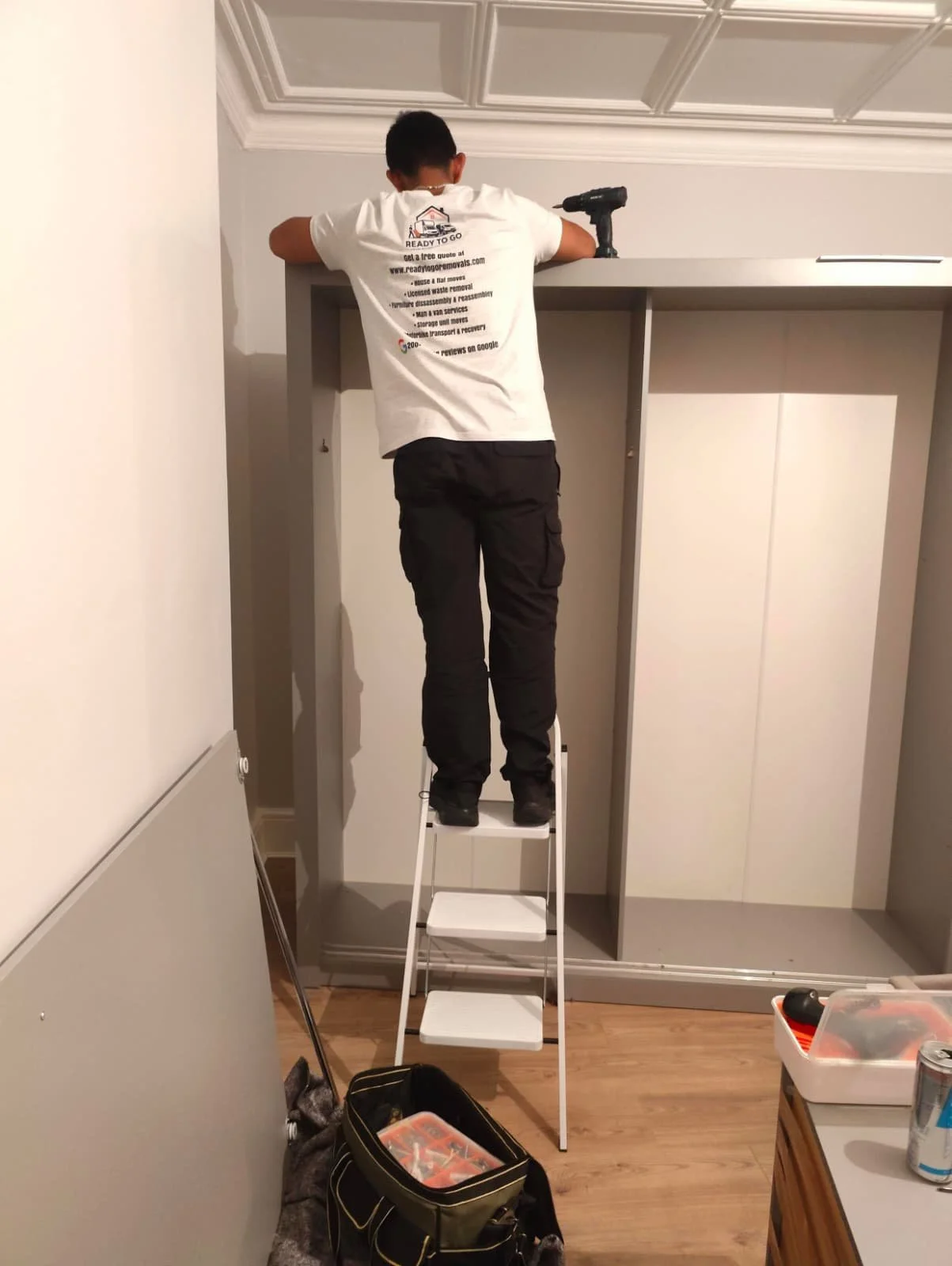 installing the lights on top of wardrobe while putting it back together from Ready To Go Removals