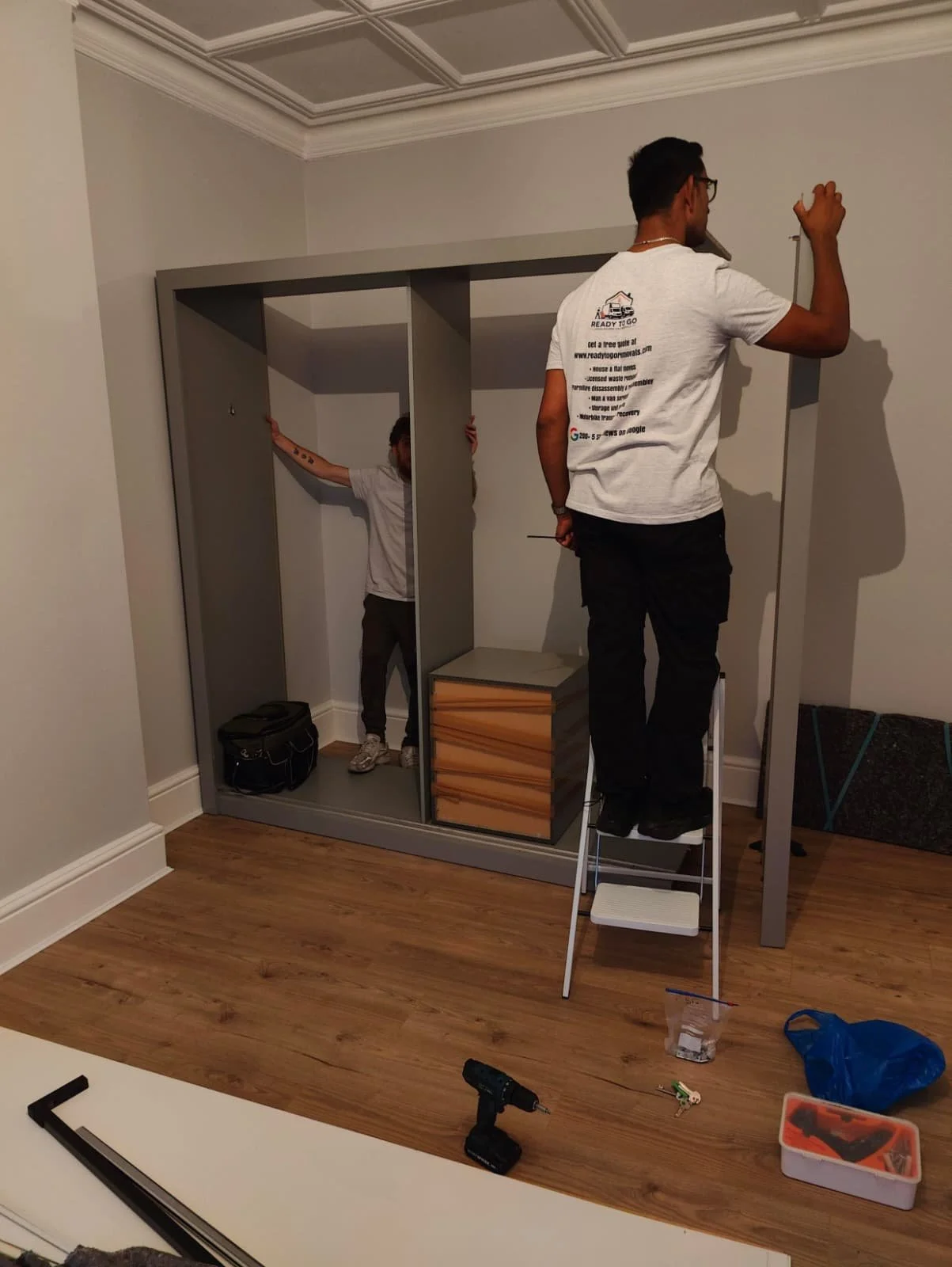 Large grey wardrobe being put back together by Ready To Go Removals