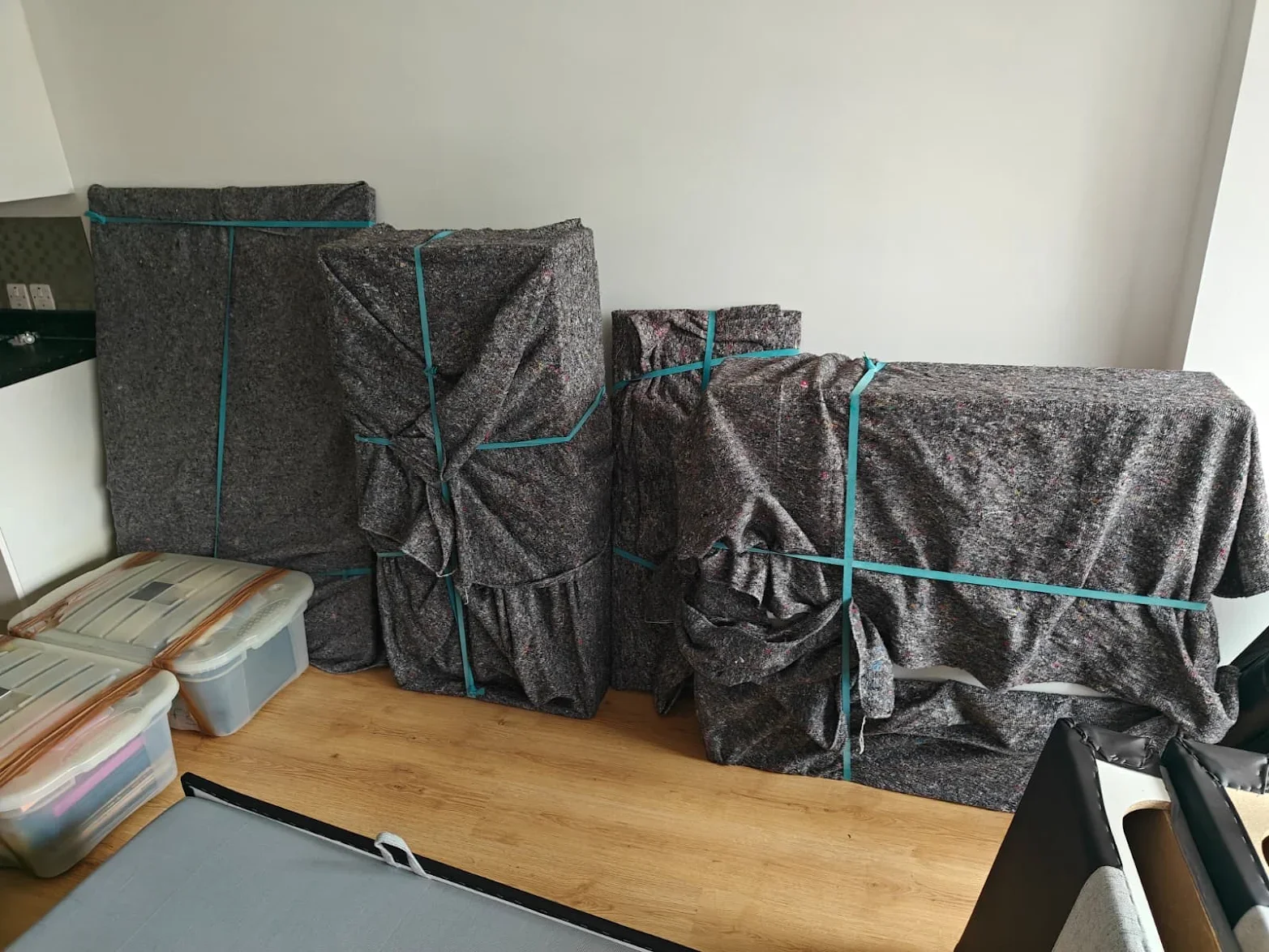 Pieces of furniture wrapped in removal blankets during a flat move by Ready to go house movers and removals