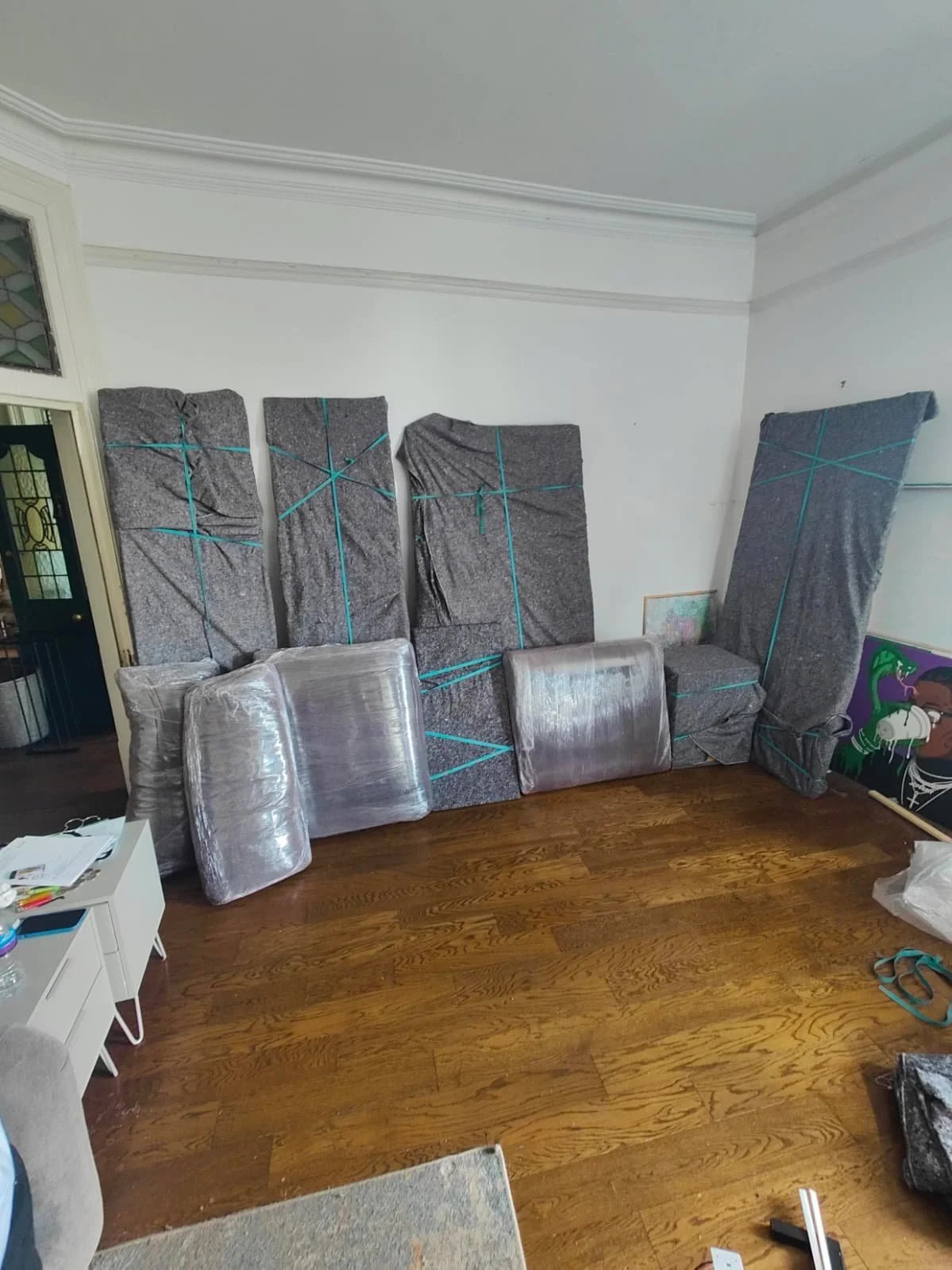 Wardrobe disassembled and wrapped in removal blankets with bands. Sofa cushions also wrapped with shrink wrap to keep everything safe and clean during house moves. 
Ready to go house movers and removals going the extra step to protect clients items