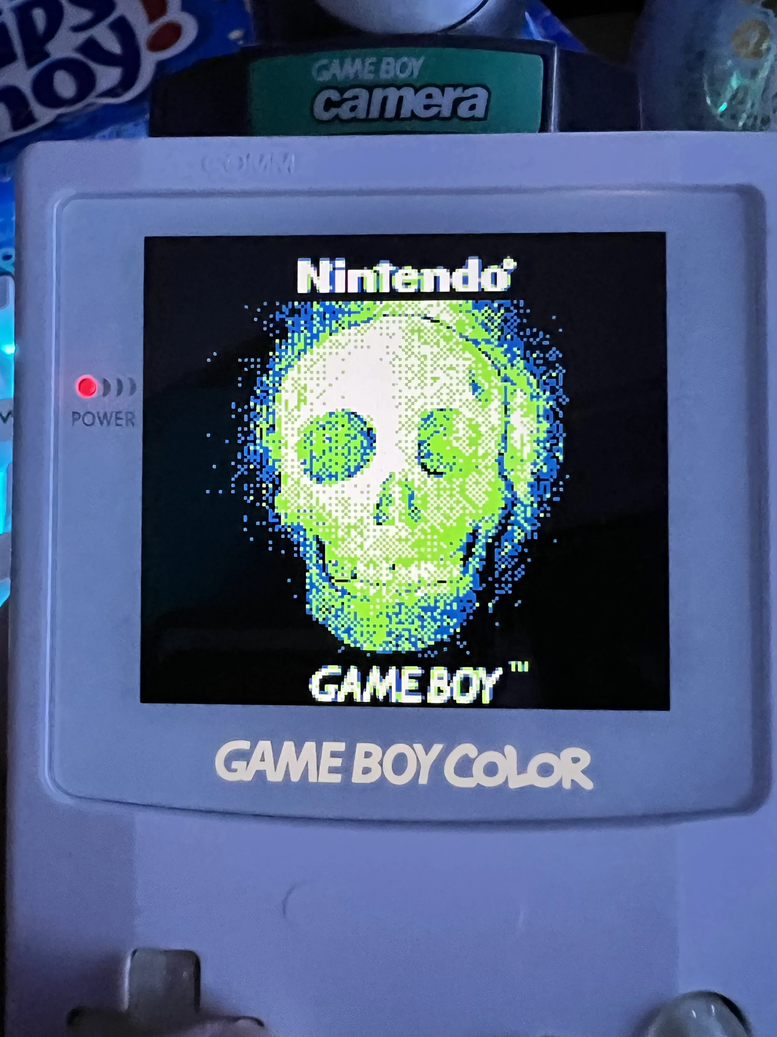 A Nintendo Game Boy Color screen displaying a pixelated skull with the word 'Nintendo' above it and 'GAME BOY' below it.