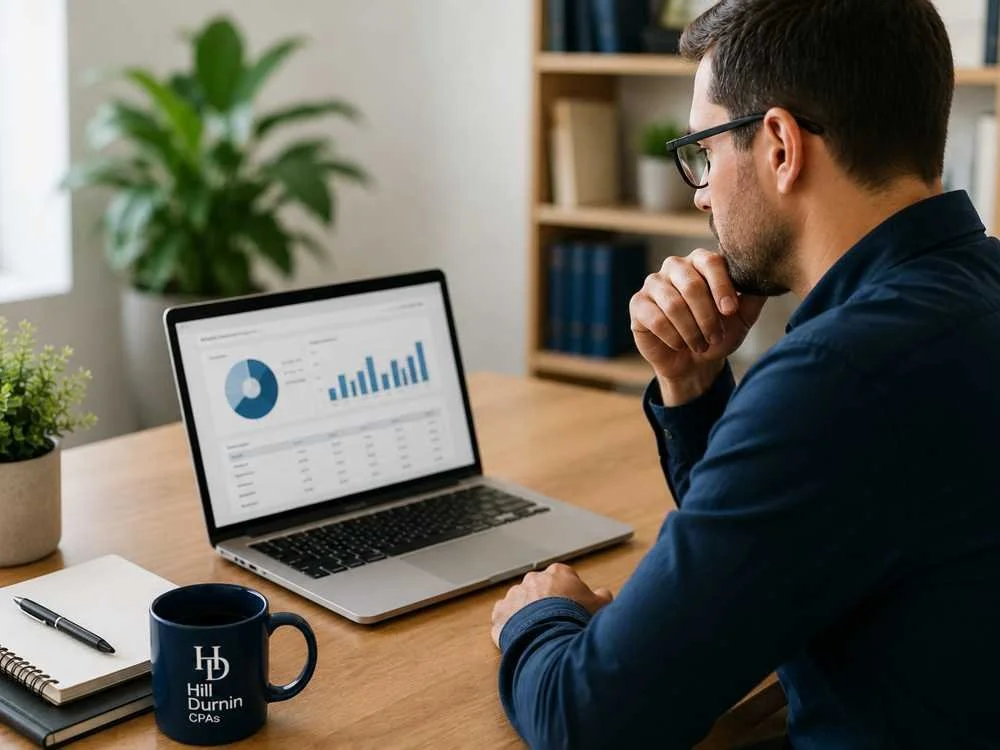 Small business owner reviewing financial records while considering outsourced bookkeeping