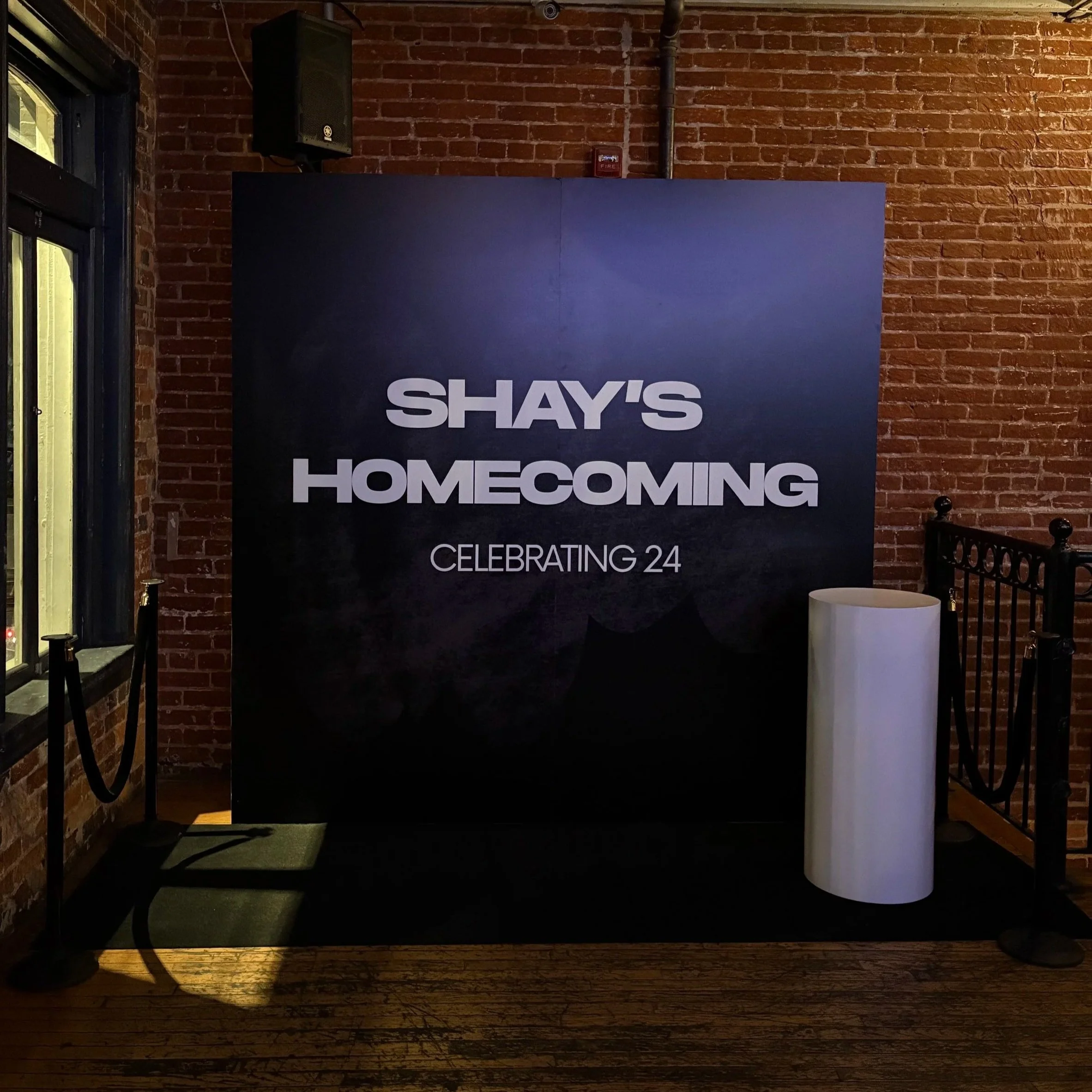 Custom 7.5 ft × 7.5 ft black square event photo wall and backdrop installation at an evening celebration.