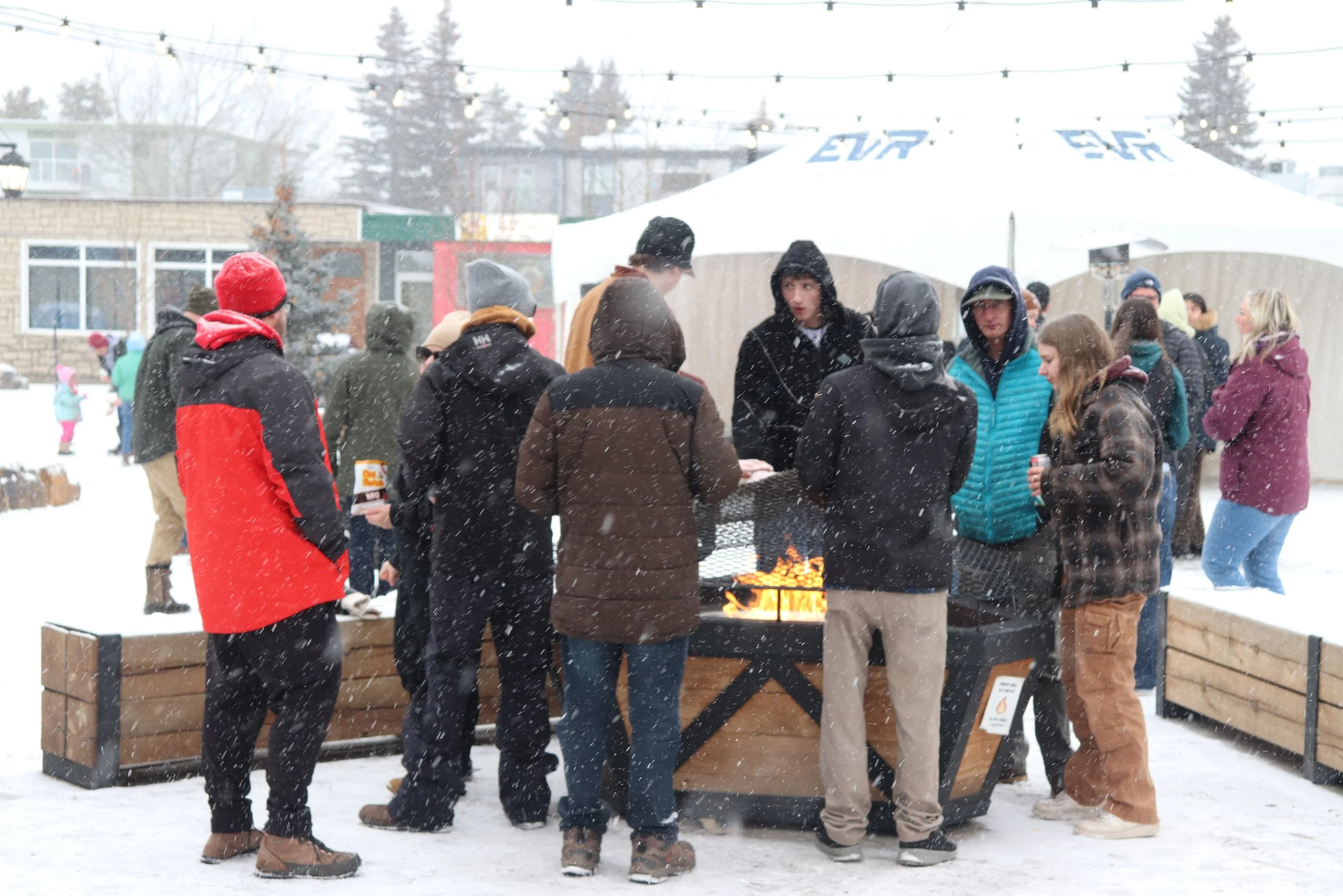 People warm up by a fire during Winterfest at Centennial Plaza in Sparwood on Feb. 16.
