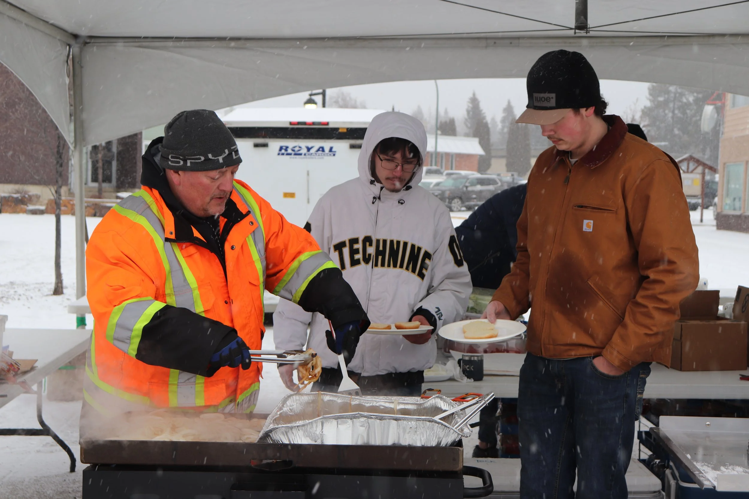 Volunteers cook burgers at the Sparwood Secondary School grad fundraiser barbecue during Winterfest at Centennial Plaza in Sparwood on Feb. 16.