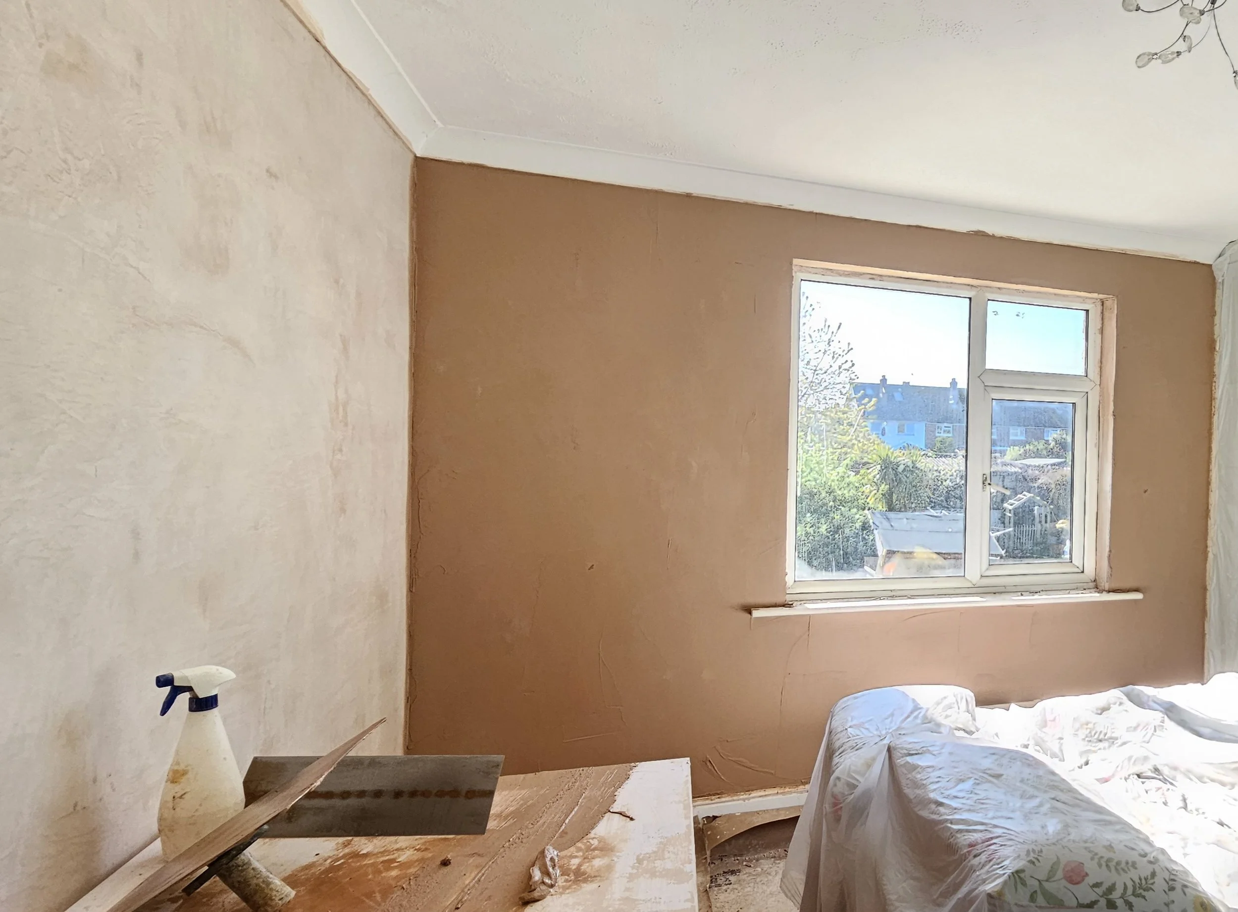 A room under renovation with fresh plaster on the walls.
