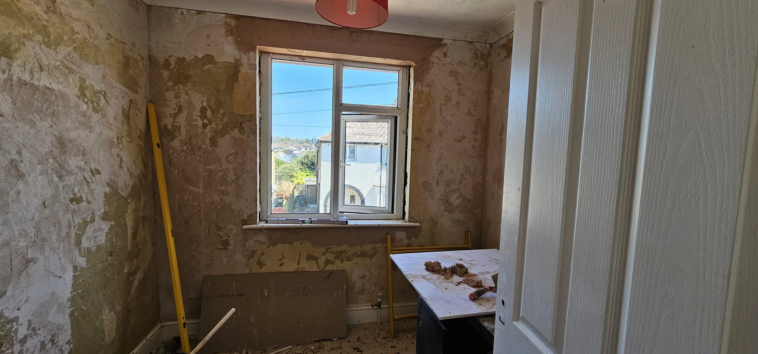 Room under renovation with peeling walls.