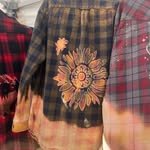 Close-up of three different plaid shirts hanging side by side.