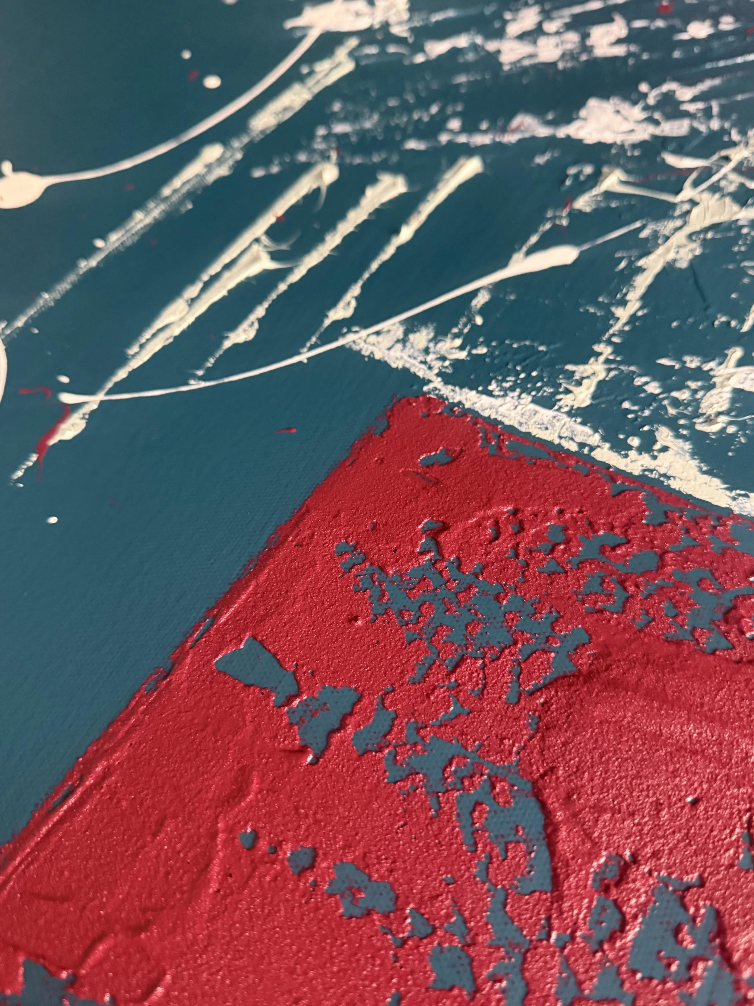 Détail d'une peinture abstraite avec des éclaboussures blanches sur un fond bleu et une zone rouge en relief.