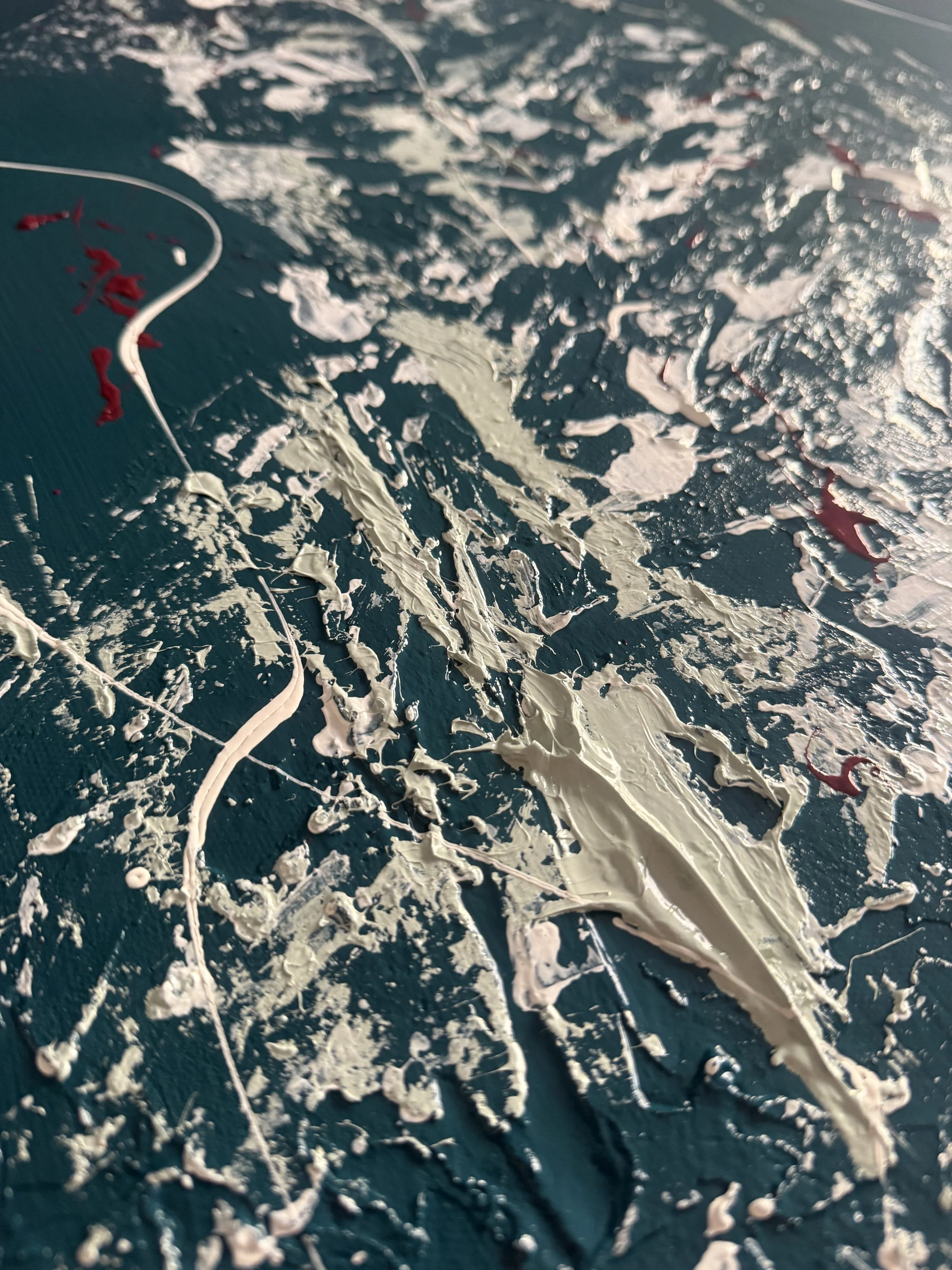 Peinture abstraite avec des coups de pinceau blancs, peints sur une toile bleue, avec de petites touches de rouge.