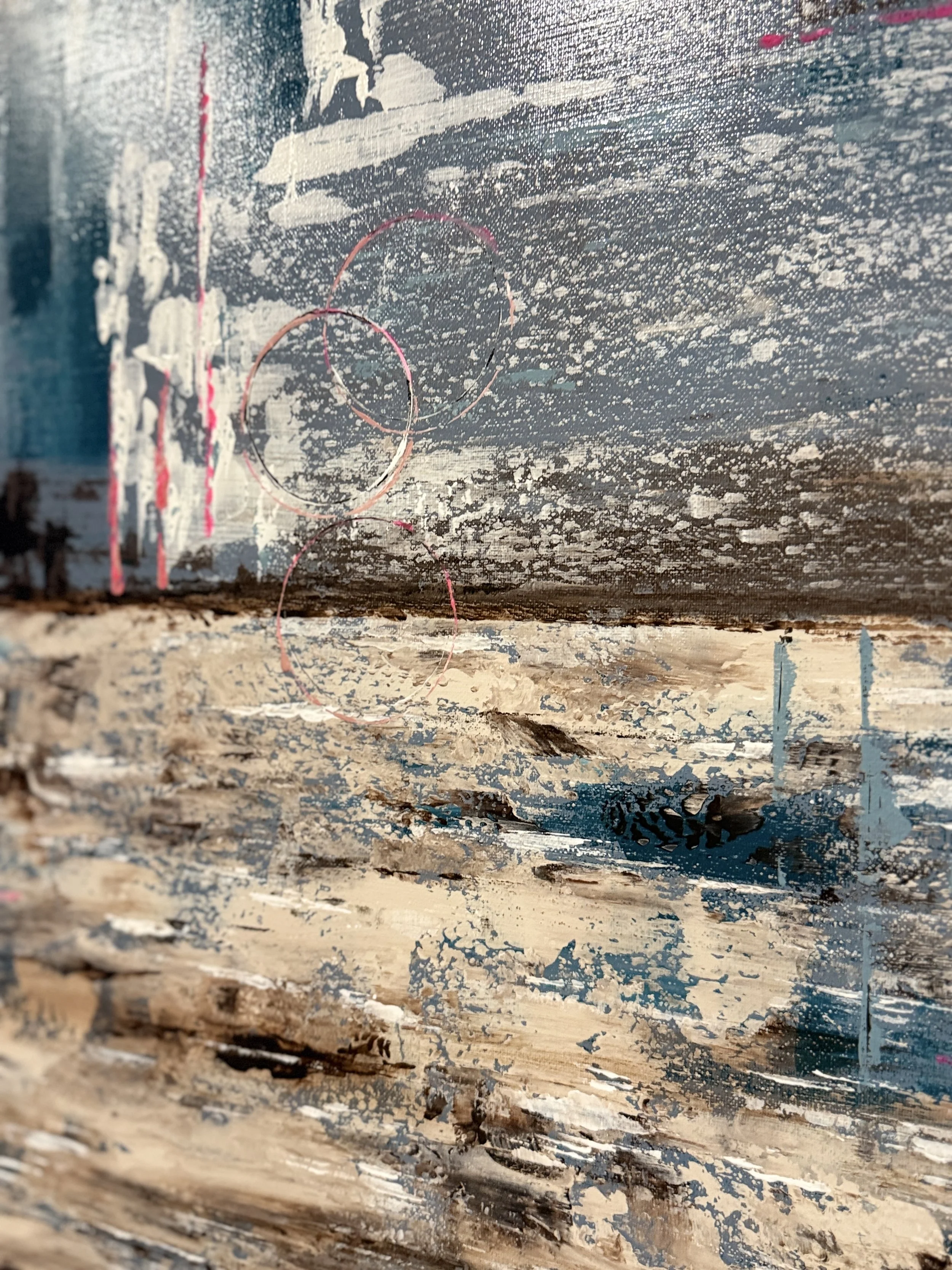 Une peinture abstraite représentant une scène marine avec une surface en bois, des cercles en lignes rouges ou roses, et des touches de couleurs bleues, blanches, et noires.