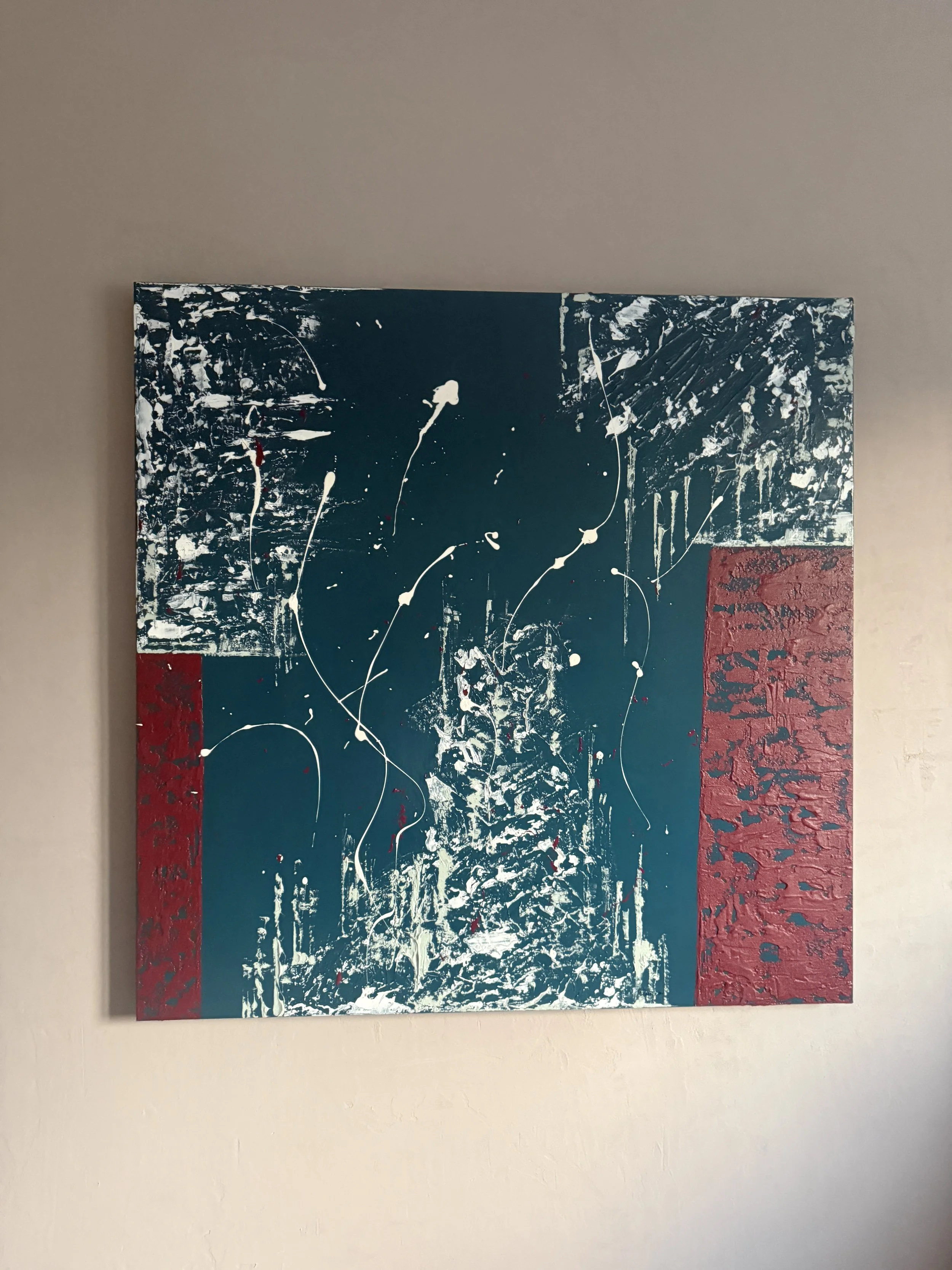 Peinture abstraite avec des couleurs bleu, blanc et rouge sur un mur beige.