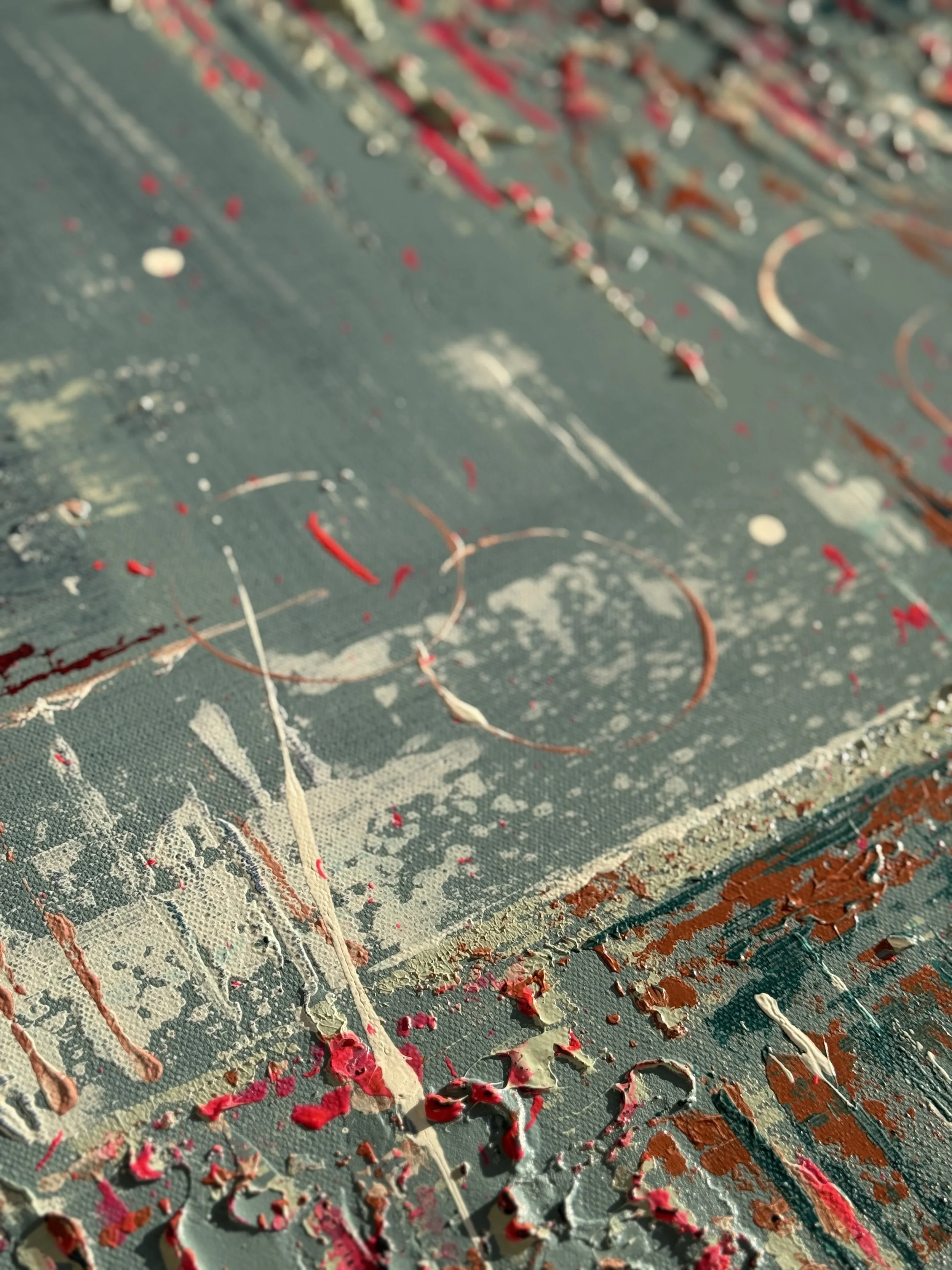 Détails d'une toile d'art abstrait avec éclaboussures de peinture en rouge, blanc, et beige, avec de cercles de peinture.