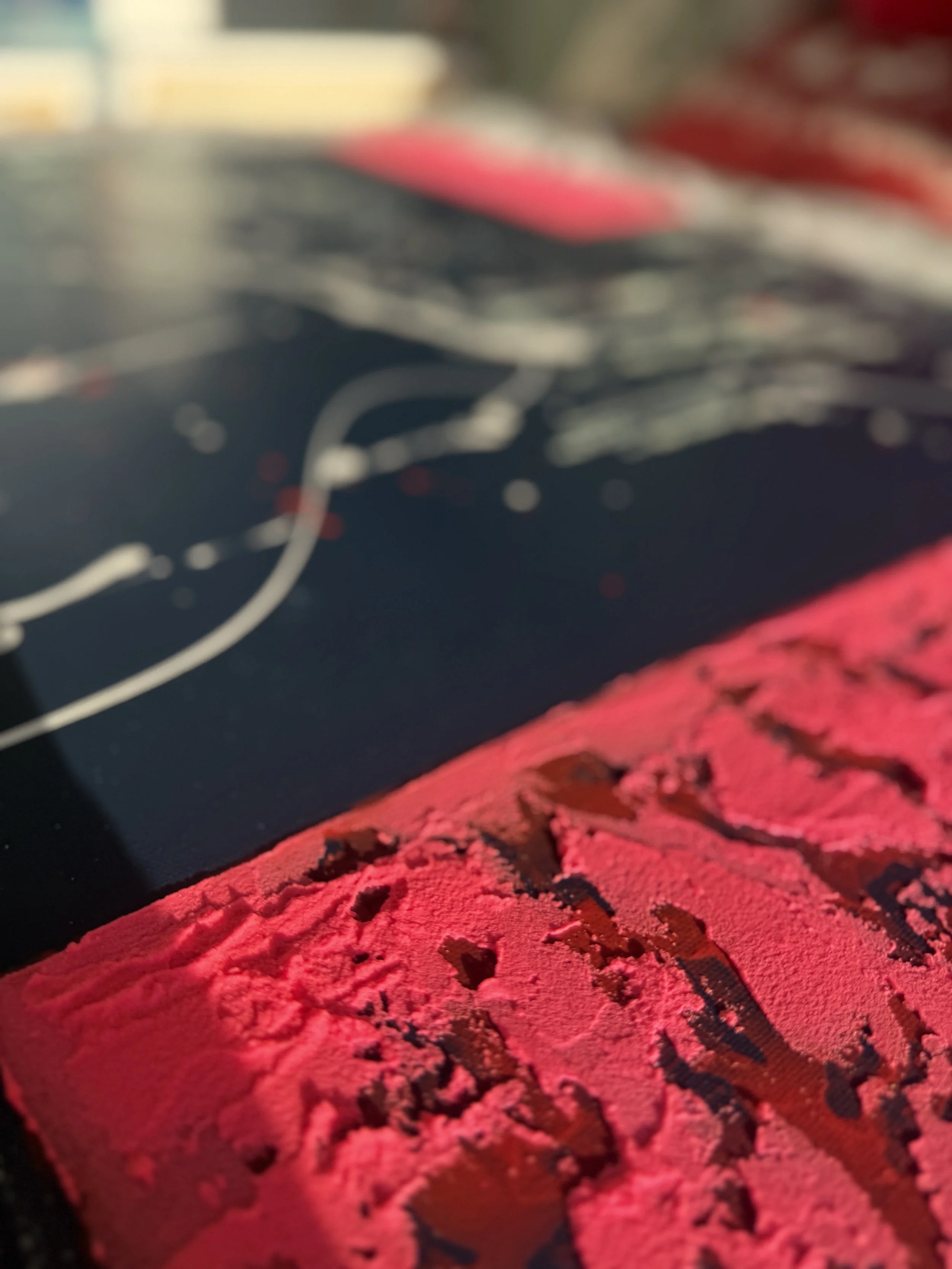 Gros plan sur une surface rouge qui semble être de la poudre ou de la craie, avec un fond flou et sombre.