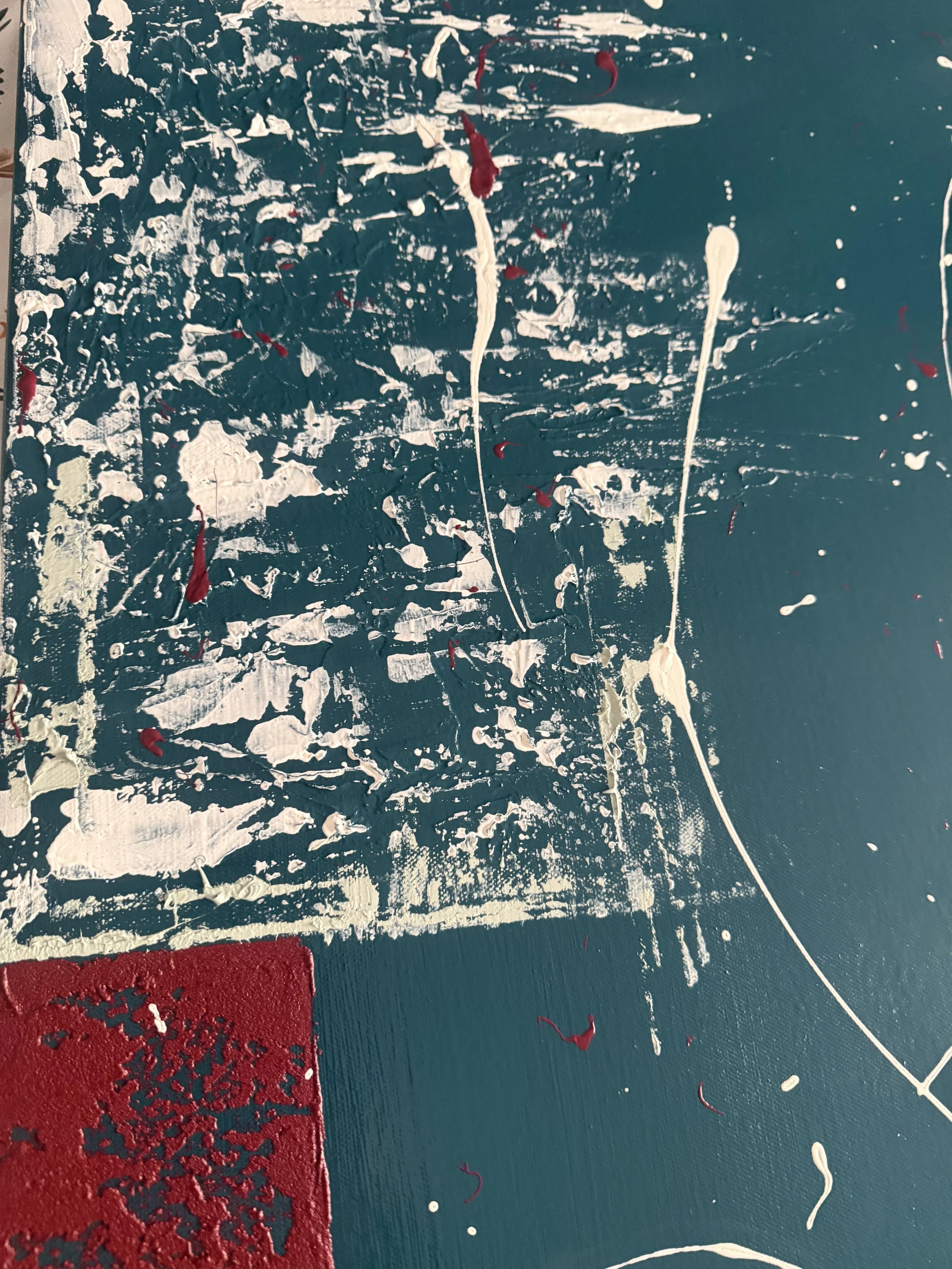 Peinture abstraite avec des éclaboussures de blanc, de rouge et de beige sur un fond bleu vert avec un coin rouge texturé.
