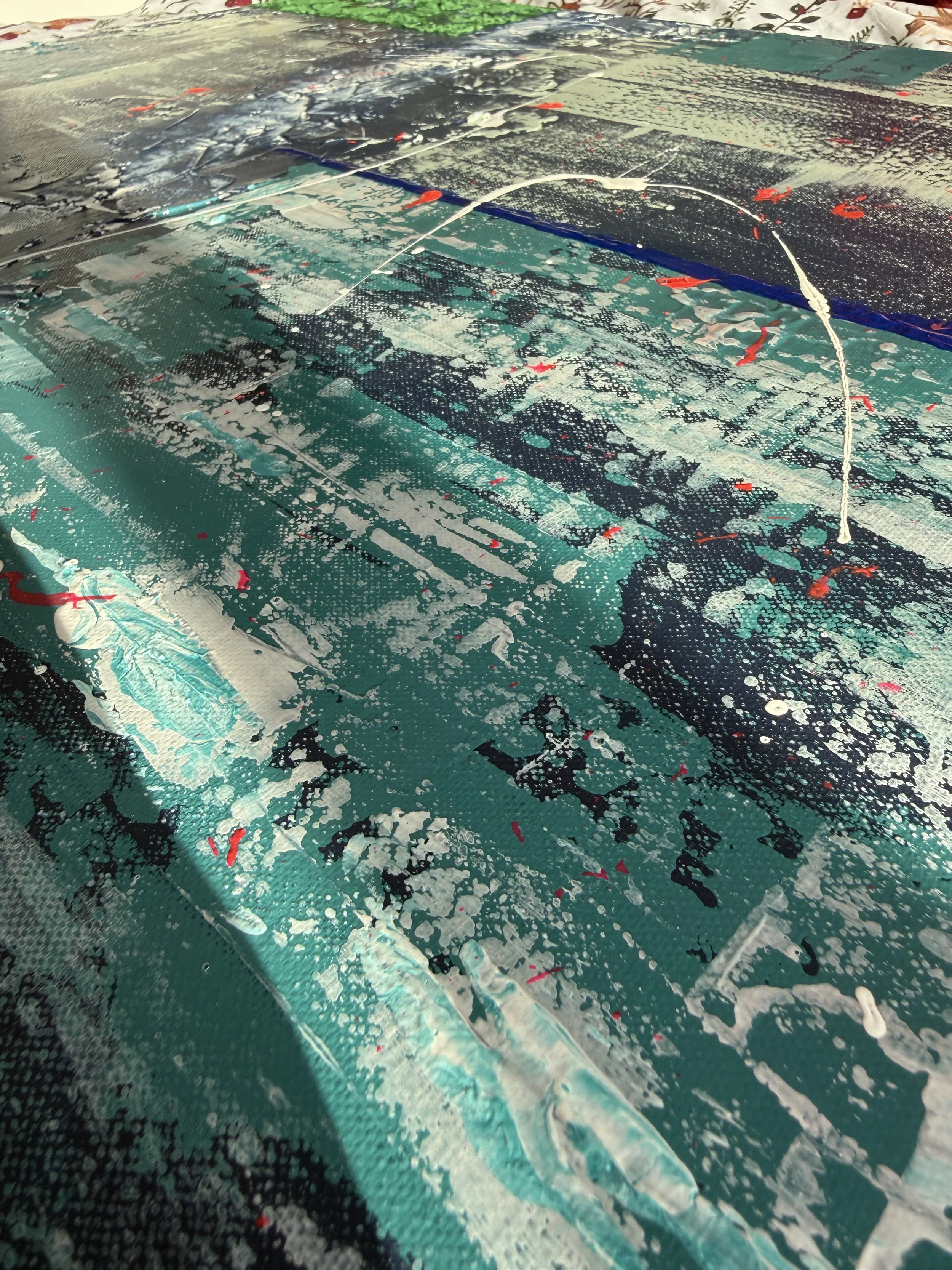 Peinture abstraite sur toile avec des taches, des lignes et des éclaboussures en blanc, noir, turquoise et rouge.