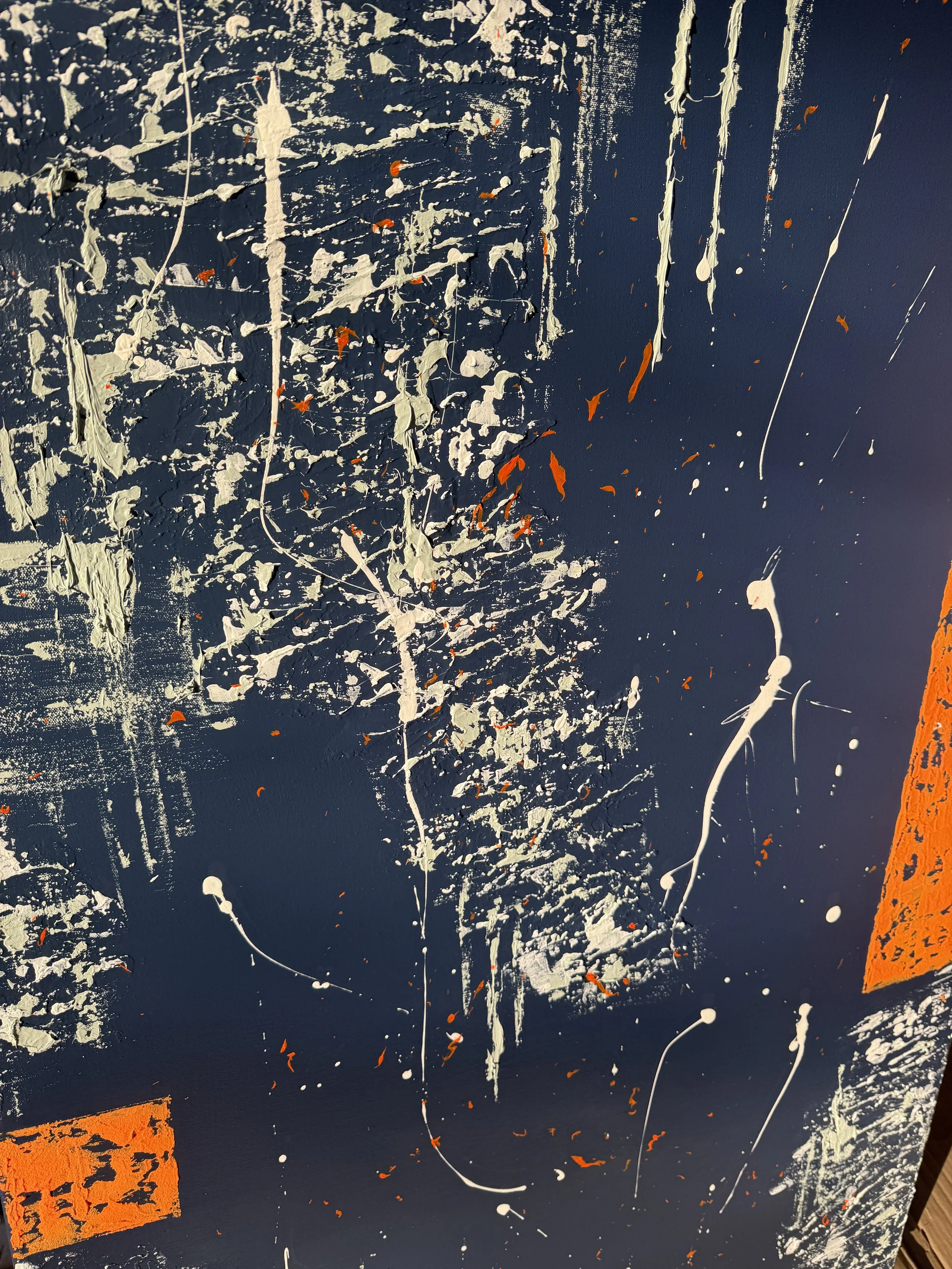 Peinture abstraite avec éclaboussures de blanc, de noir et de petites touches d'orange. Présence de blocs orange en bas à gauche et à droite.