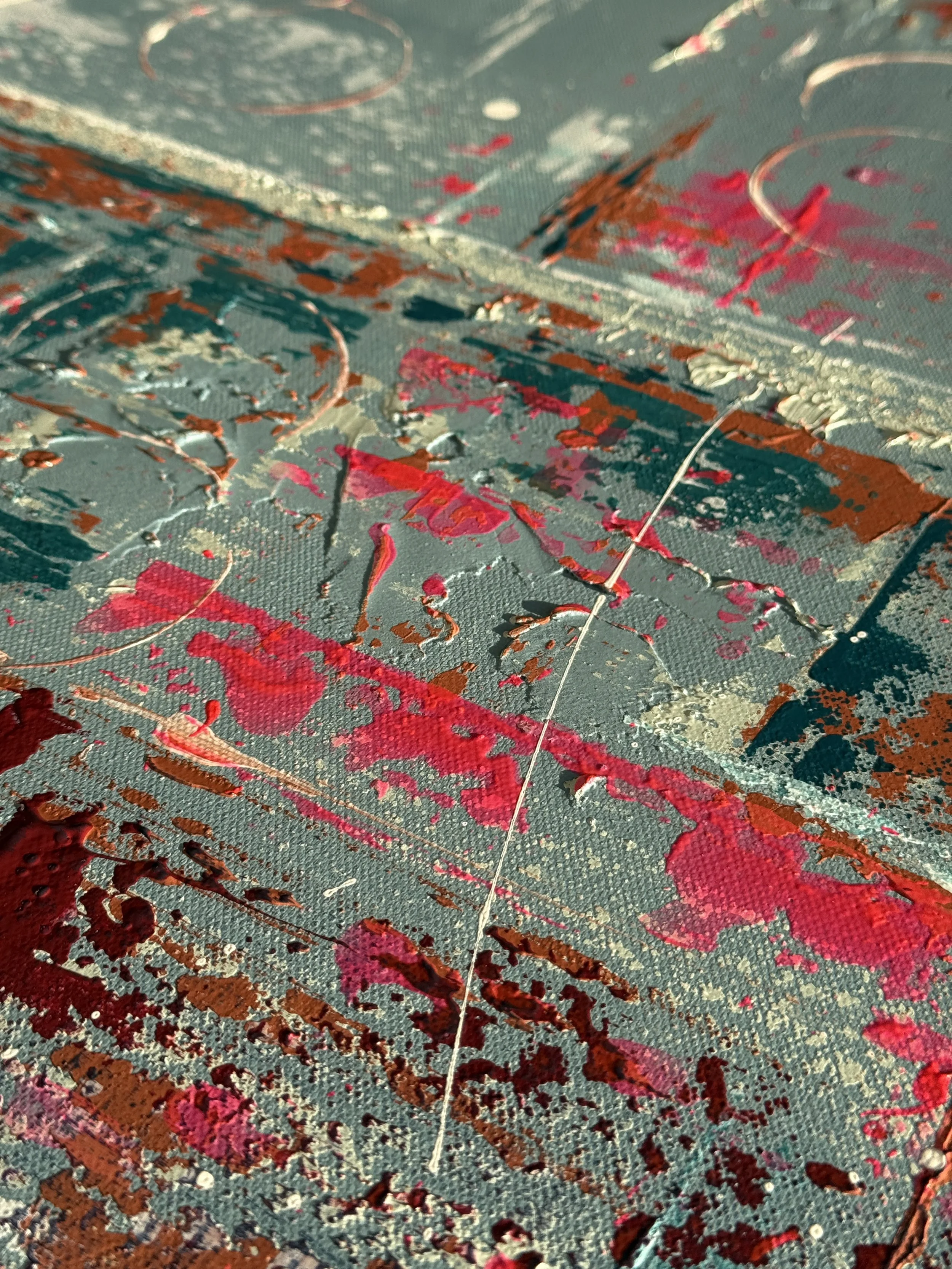 L'image montre une peinture abstraite avec des éclaboussures de couleurs chaudes comme le rouge, le rose, le orange et des touches de blanc sur une toile de couleur verte ou grise.