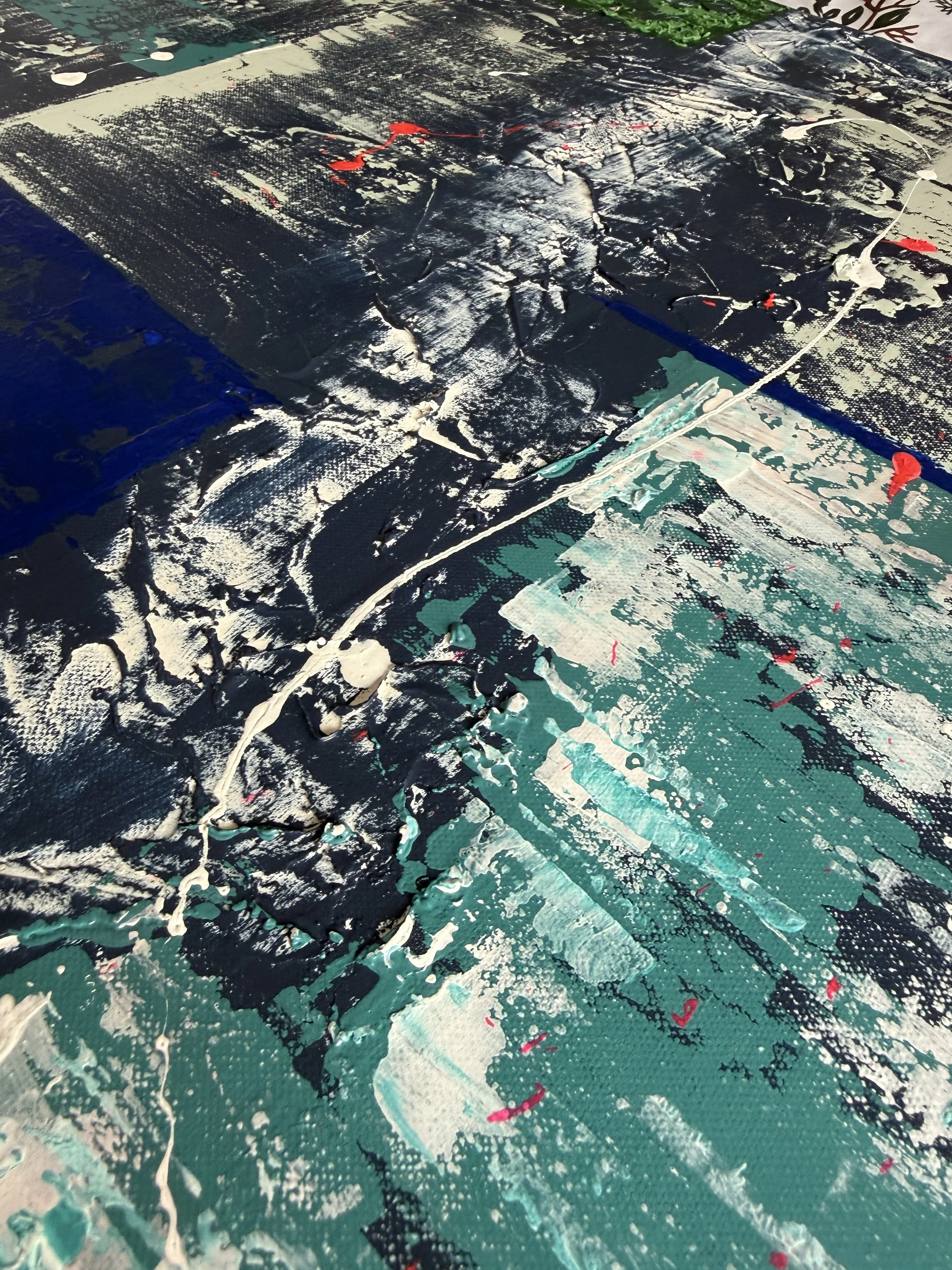 Détails d'une toile abstraite avec des textures épaisses de peinture noire, blanche, verte, avec quelques touches de rouge.