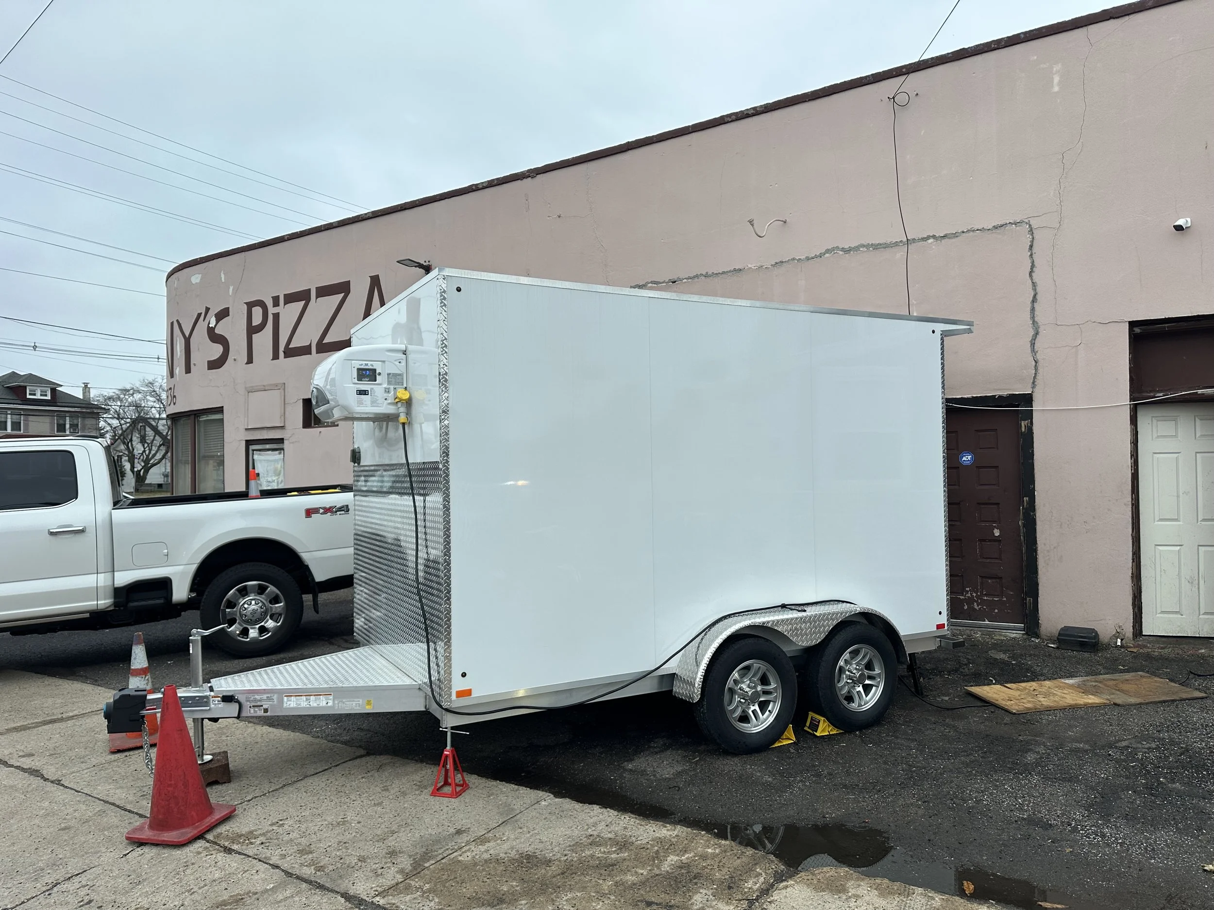 Emergency mobile walk-in cooler trailer parked behind Anthony's Pizza Palace in Trenton NJ to save $5,000 in food inventory.