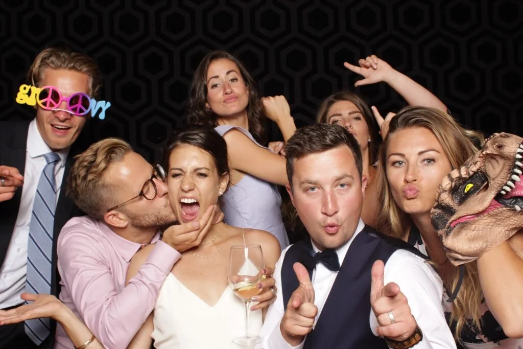 A bride and groom pose with friends in their Calgary wedding photo booth rental