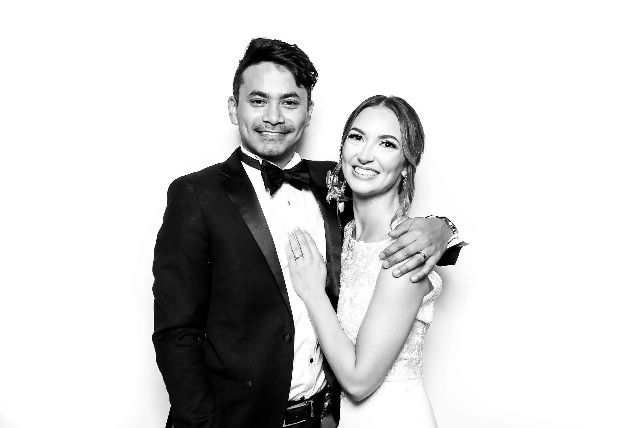 A bride and groom pose for portraits in a photographer guided studio booth