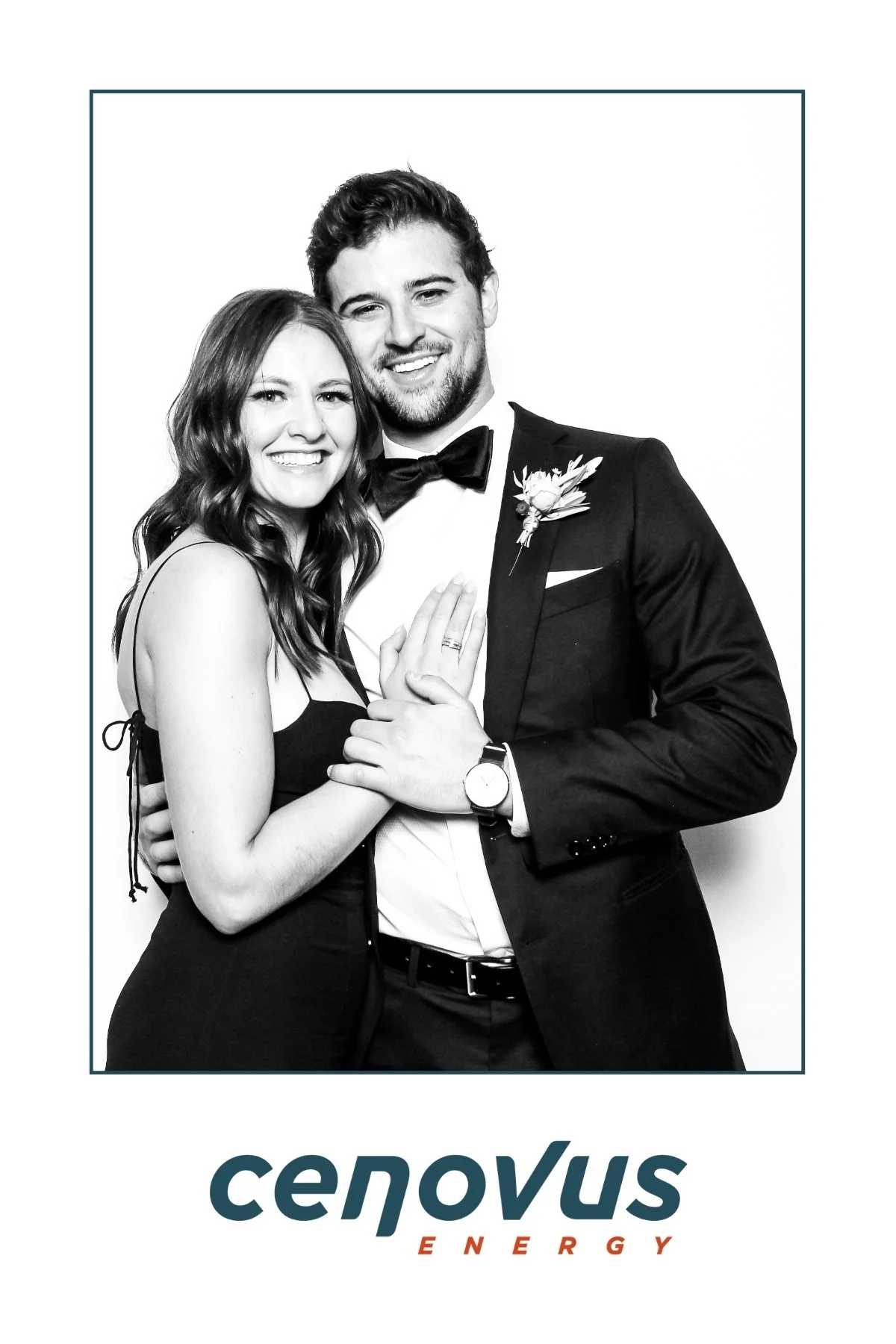 A black-and-white photo of a smiling couple dressed in formal attire, with the woman showing her engagement ring and the man wearing a tuxedo with a boutonniere. The bottom part of the image has the Cenovus Energy logo.