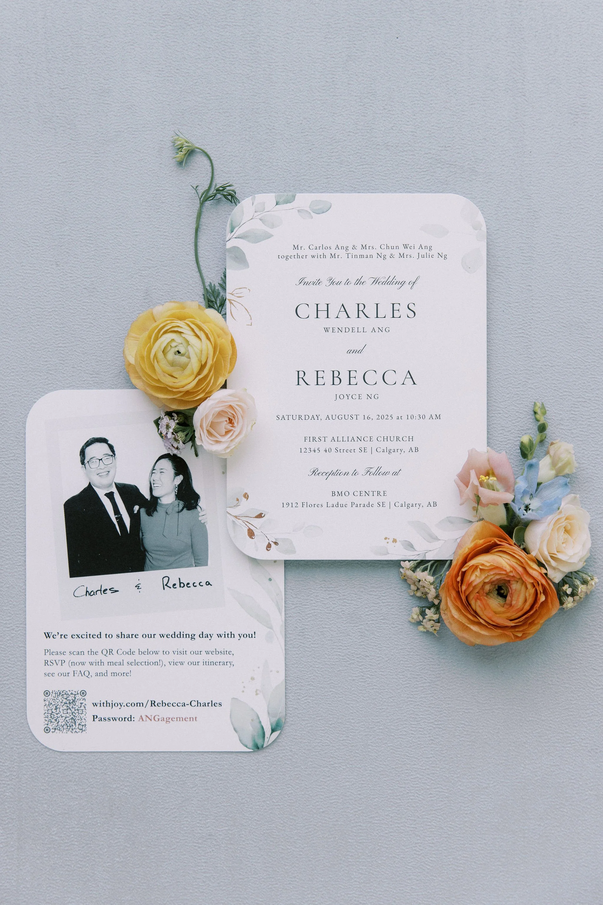 Wedding invitation card with floral decorations, a black and white photo of the bride and groom, and several colorful flowers.