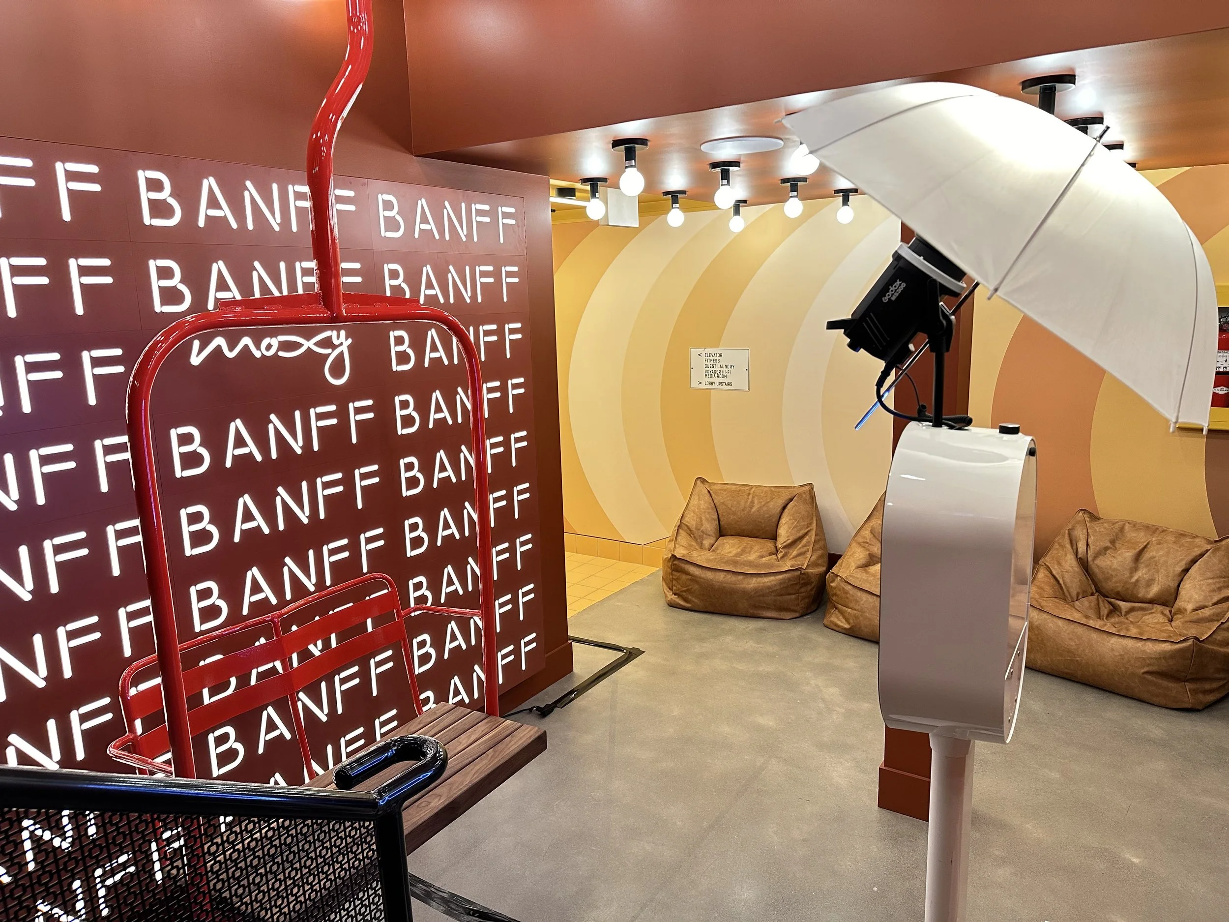 a modern flash co photo booth setup in front of a red chairlift seat at the Moxy Hotel in banff