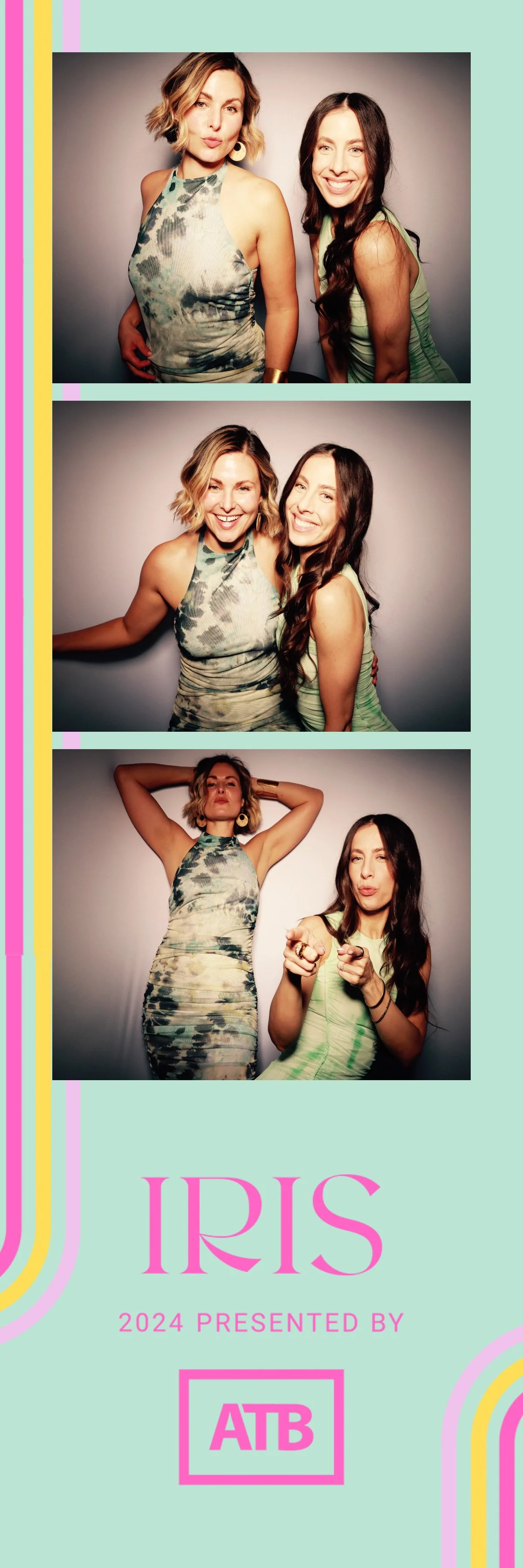 A photo booth strip featuring three pictures of two women with light skin and dark brown or blonde hair, wearing similar green and gray patterned dresses, posing playfully against a plain light gray background, with pink and yellow decorative borders