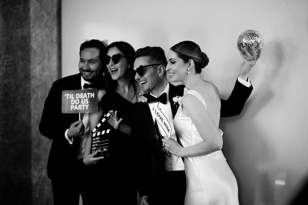 wedding guests pose in a photo booth at a wedding at the fairmont banff springs hotel