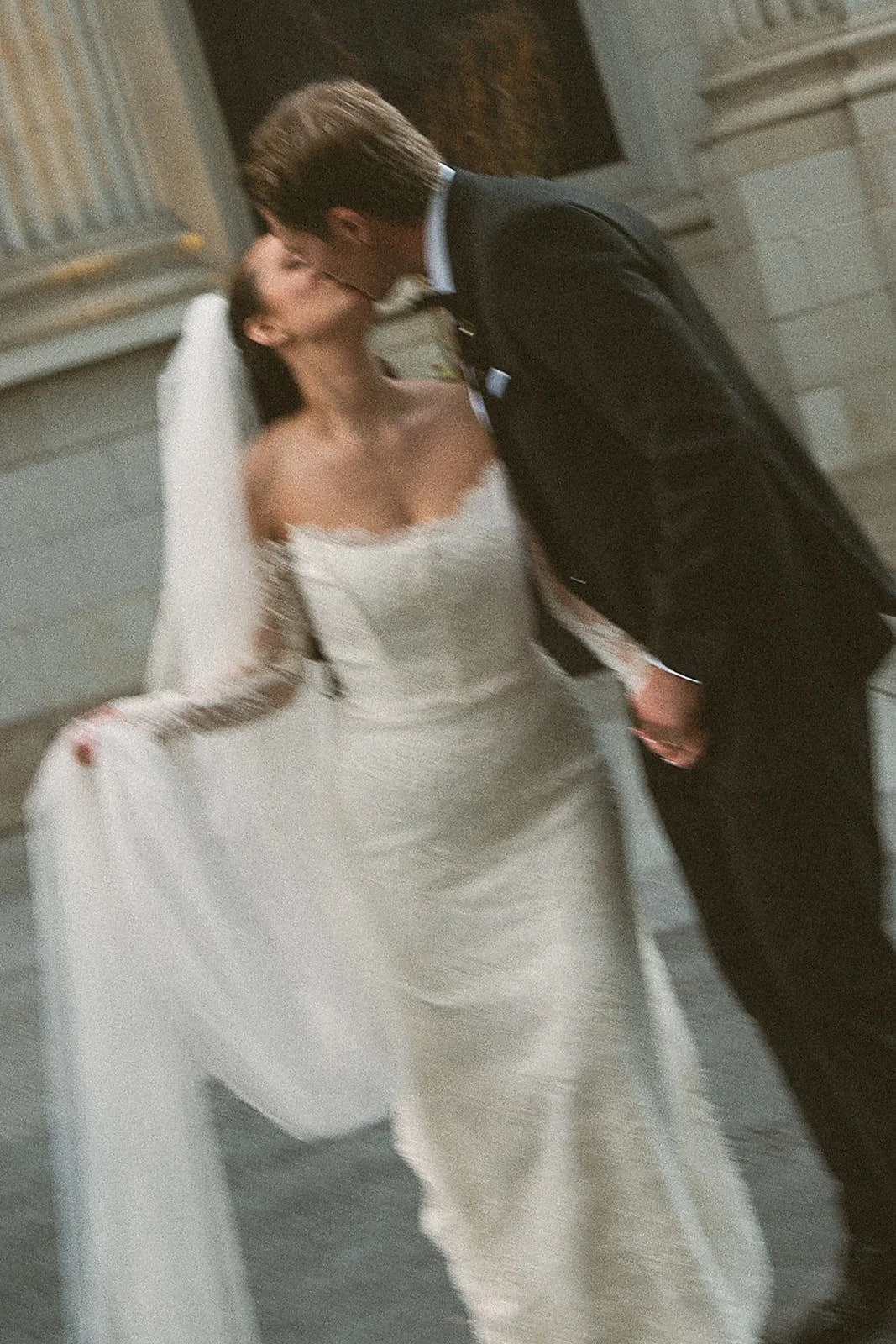 a bride and groom kiss outside Teatro Restaurant on their wedding day