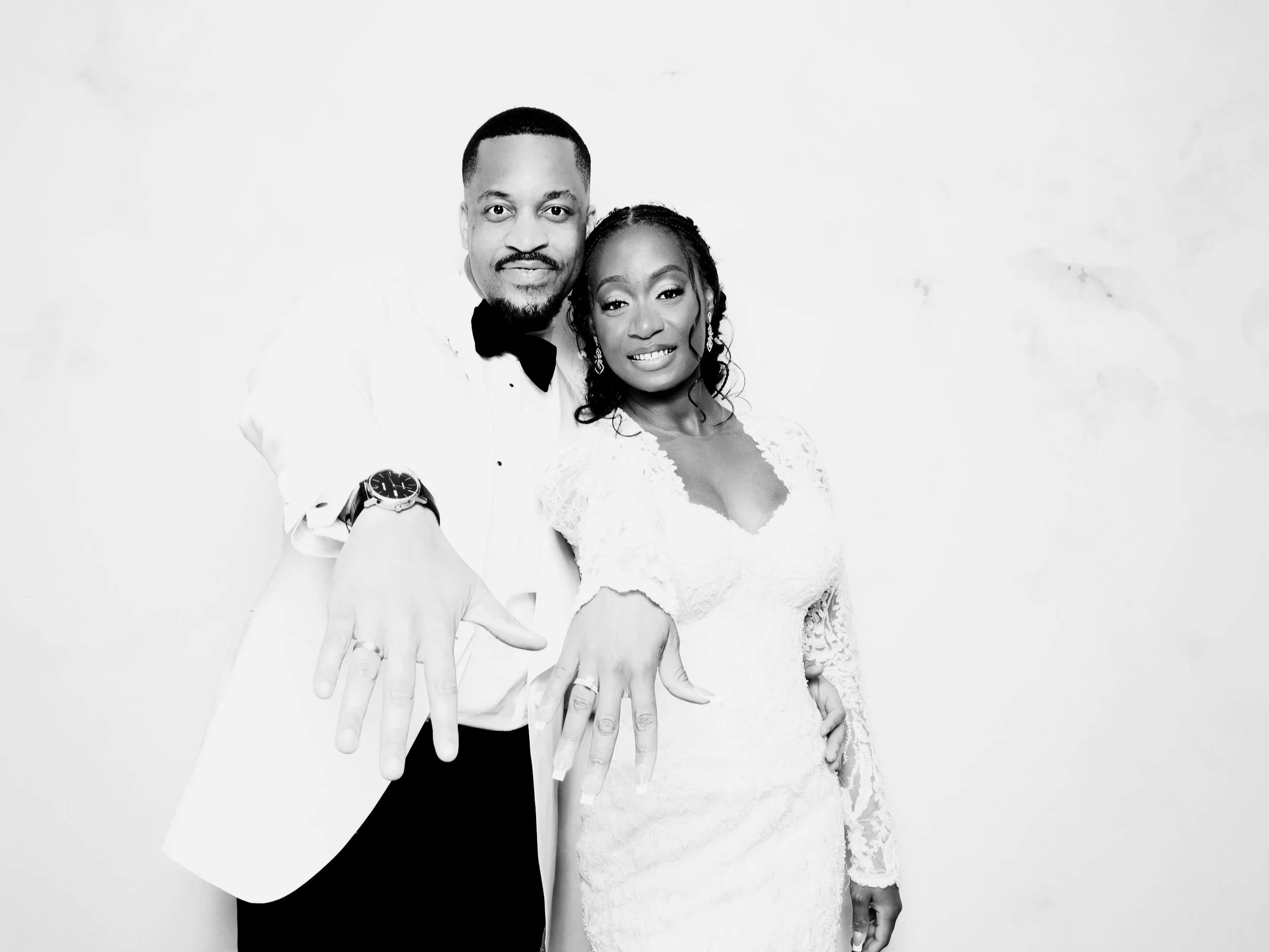 a newly married bride & groom showing off their wedding rings in a flash co glam photo booth
