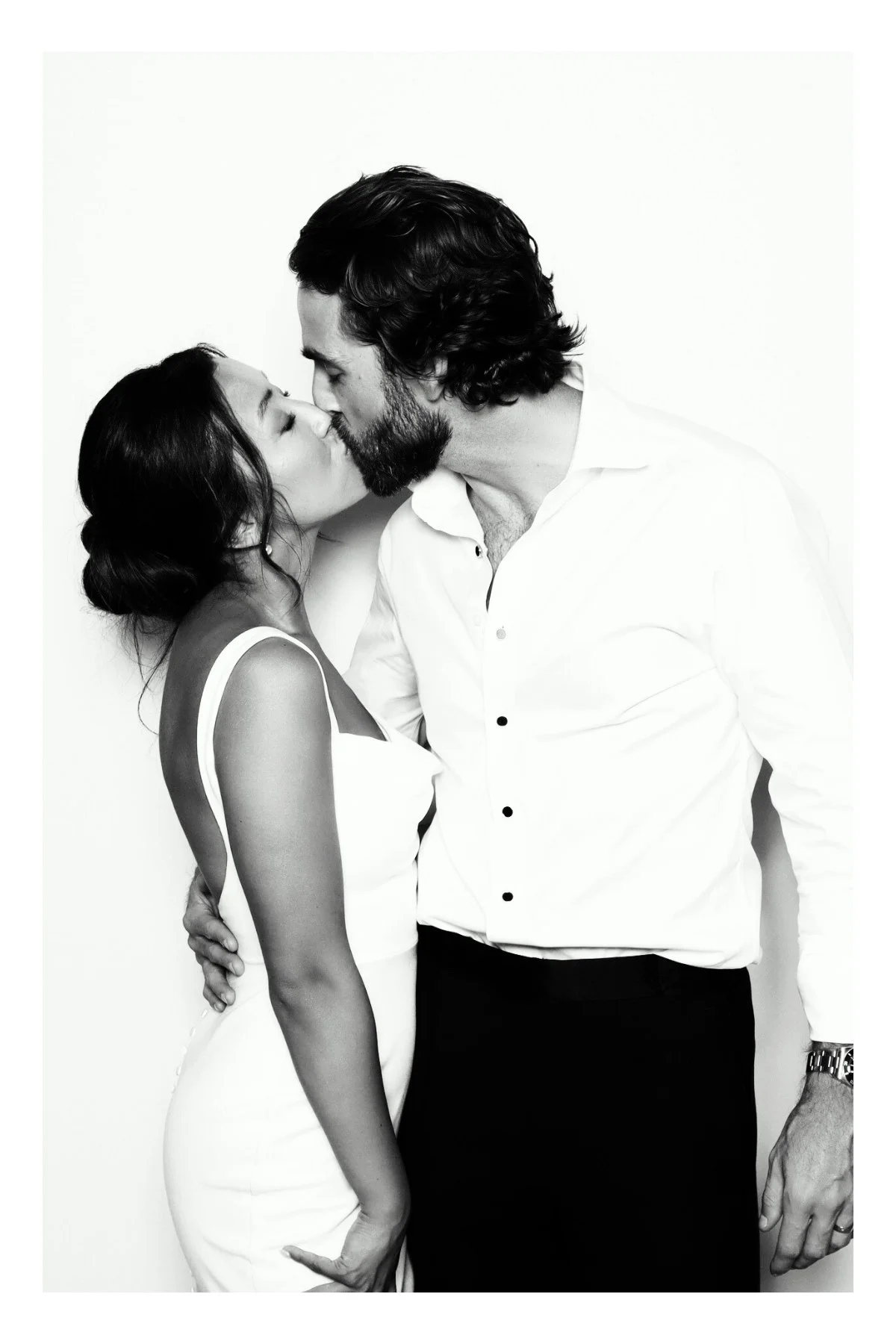 bride and groom kiss in a black and white glam photo booth by flash co.