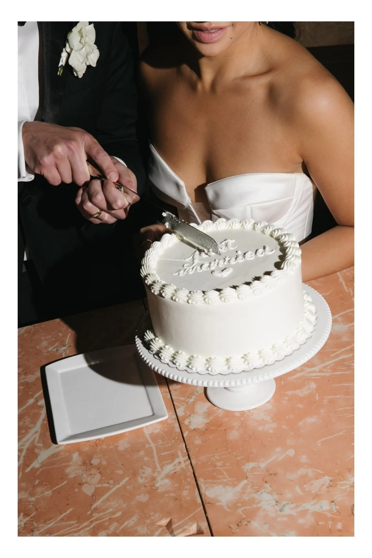 a bride and groom just into their wedding cake that reads "just married"