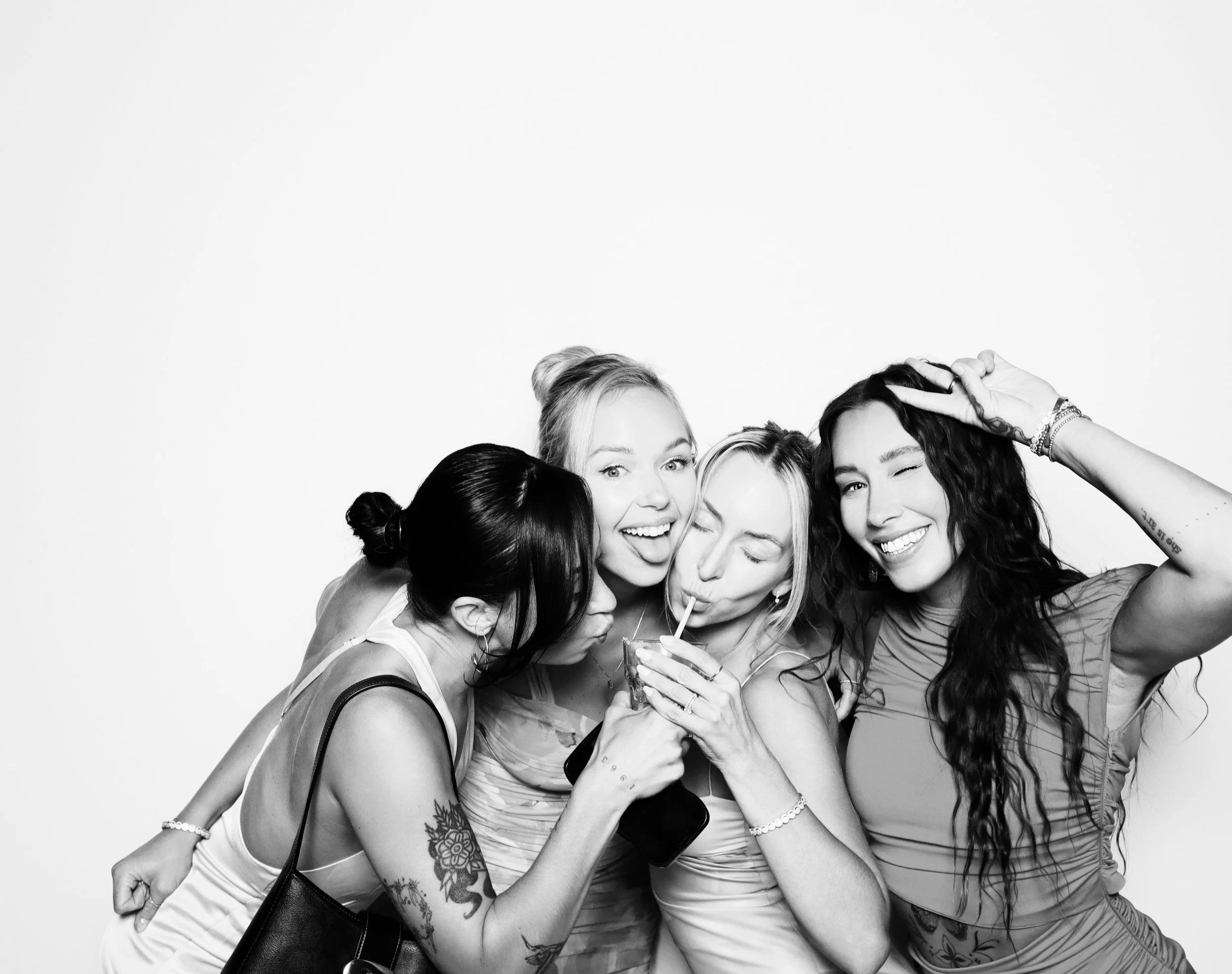 Four women enjoying drinks together, smiling and posing for the camera.