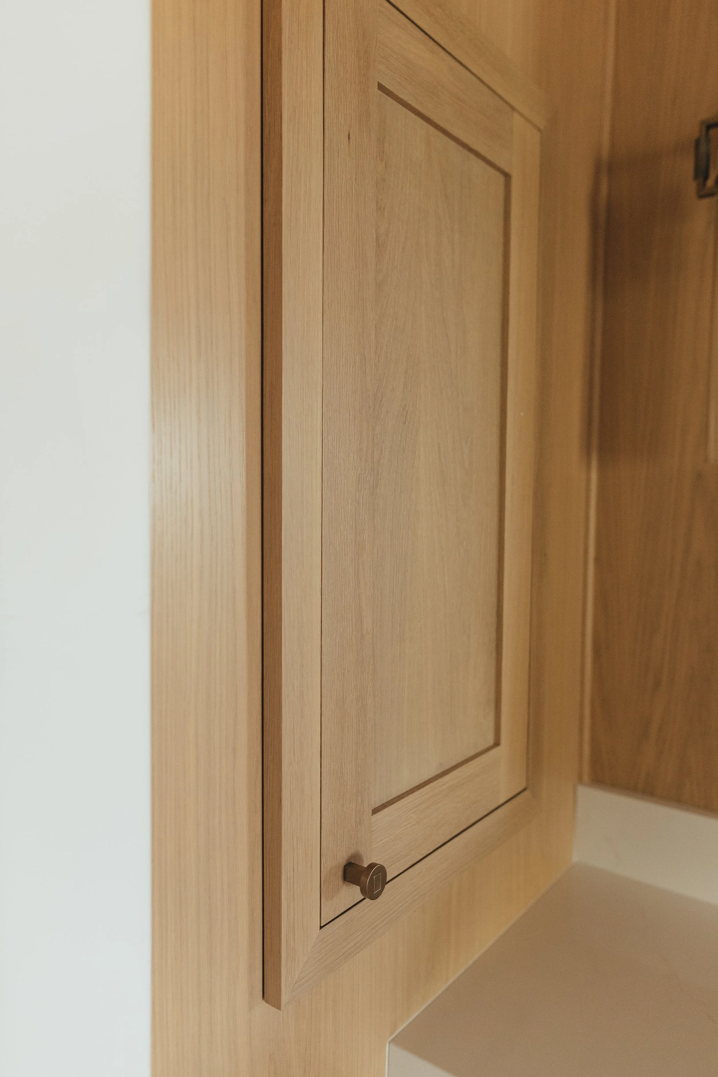 Custom white oak wall panels with hidden medicine cabinet