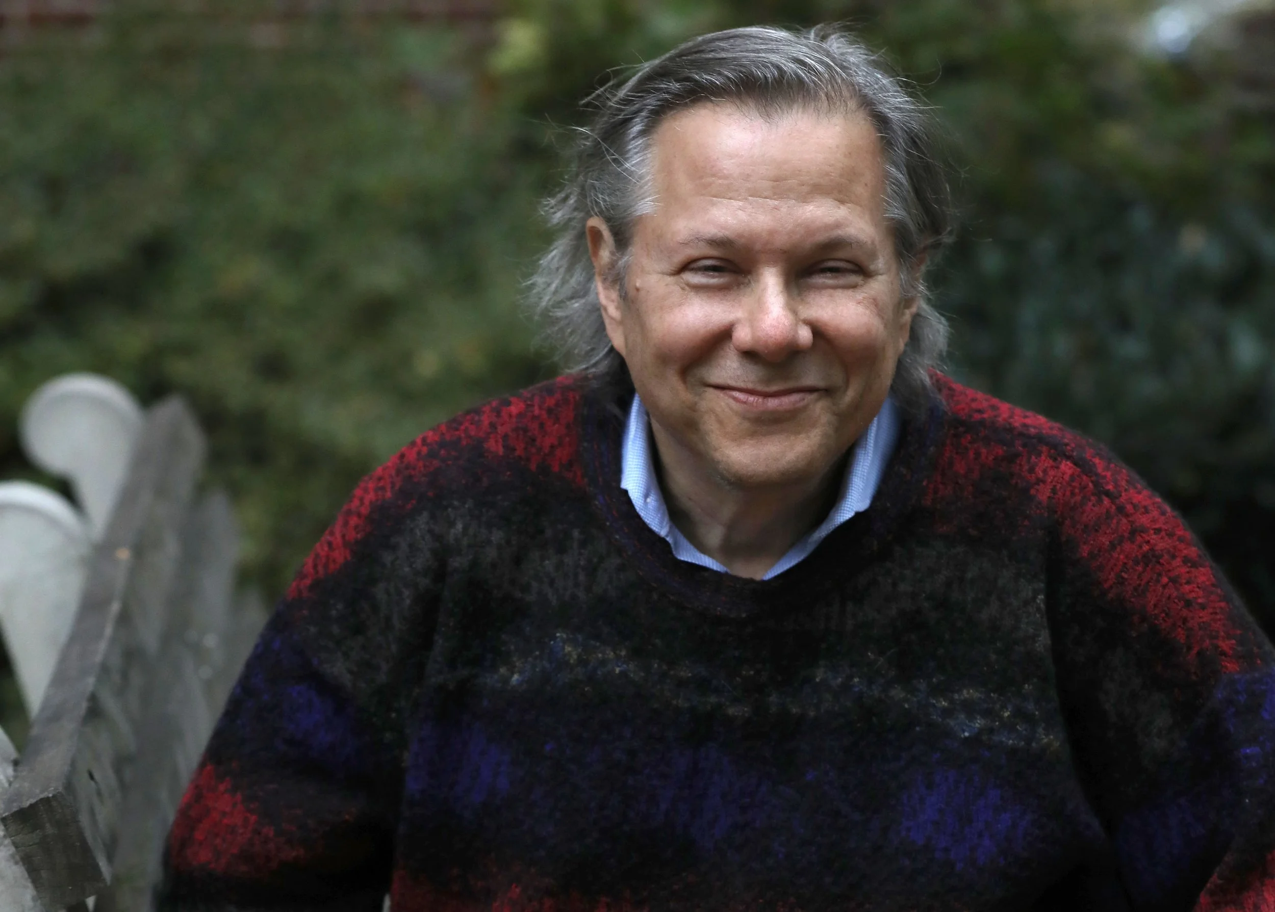 Brad Ross Headshot dressed in sweater in front of green trees with a smile