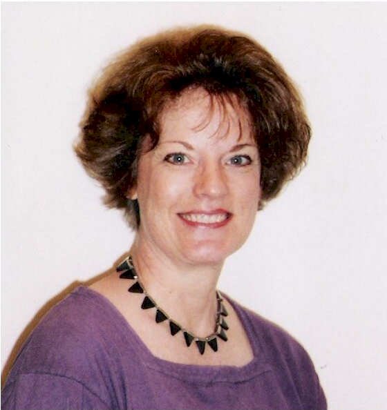 Barabara Campbell Headshot in necklace purple shirt smile