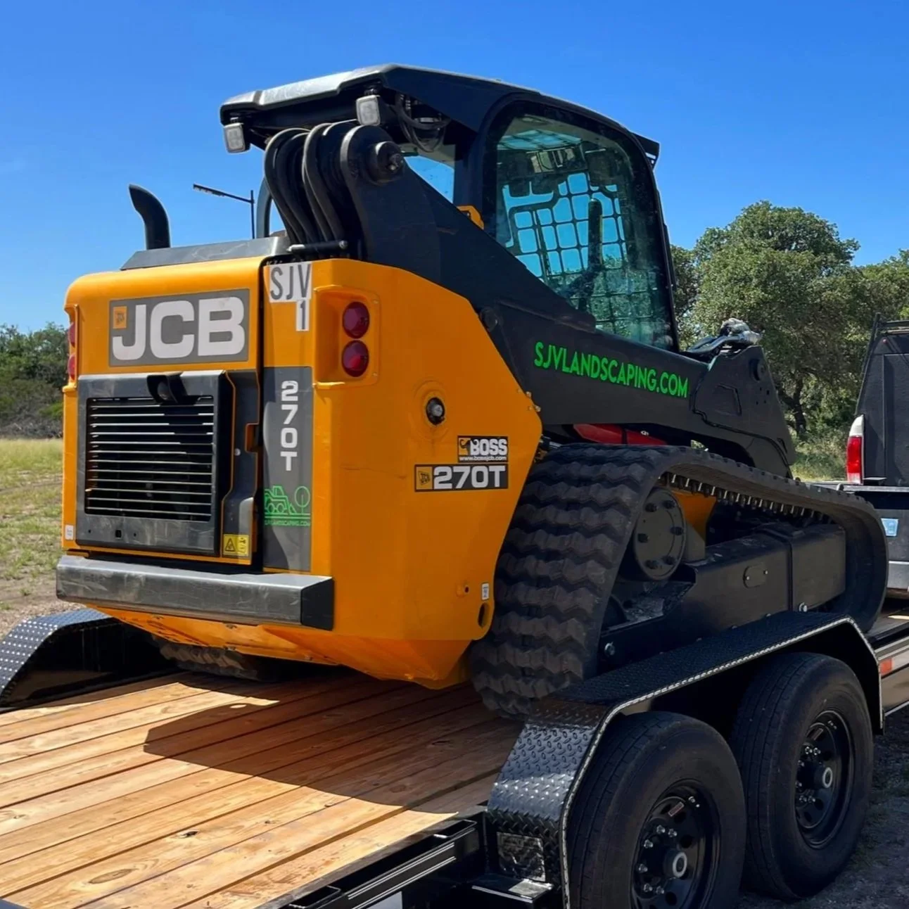 A small yellow and black JCB 270T compact track loader on a flatbed trailer.