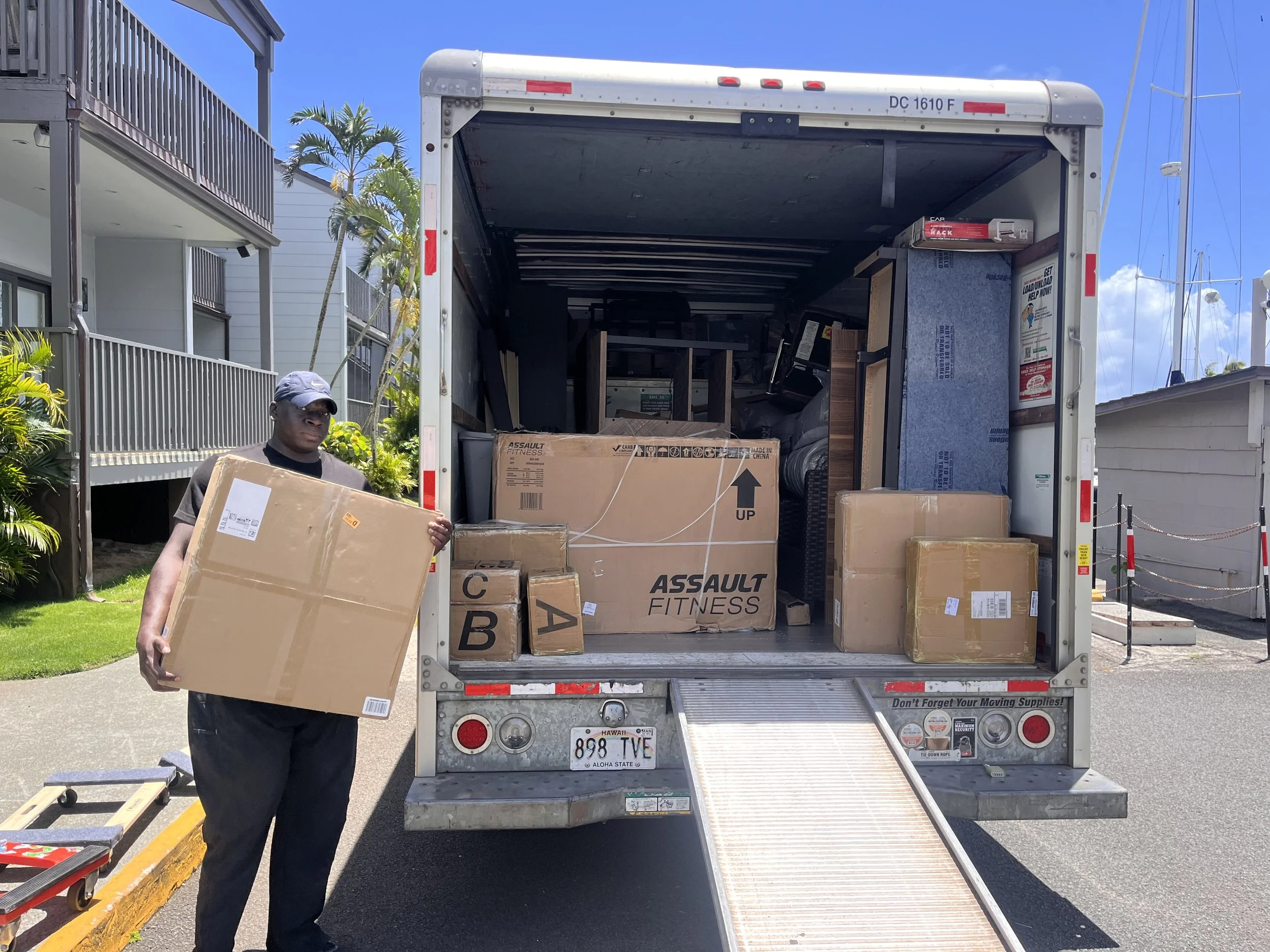 Mover standing beside the moving truck loading boxes
