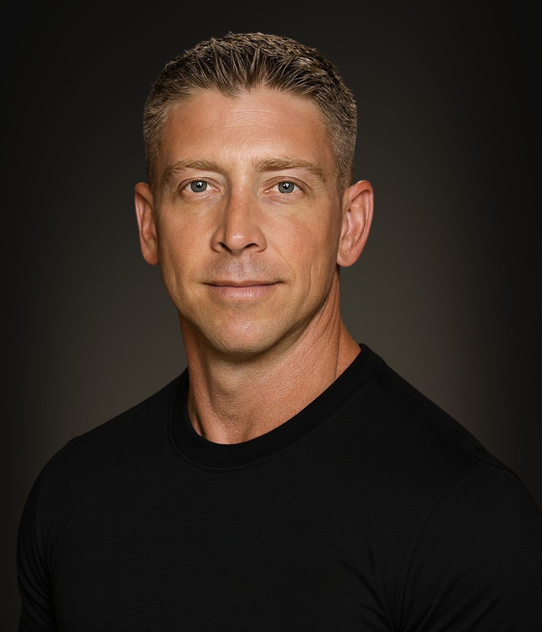 Headshot of a man with short gray hair, blue eyes, wearing a black shirt, against a dark gradient background.