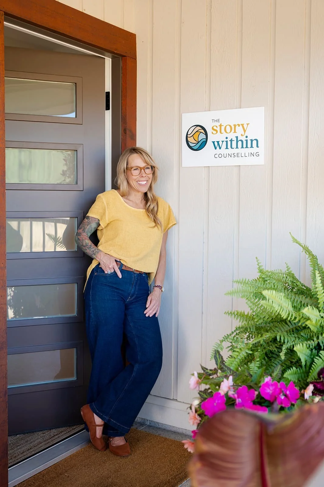 Deanna Smith standing by her sign and open office door in departure bay, Nanaimo, BC