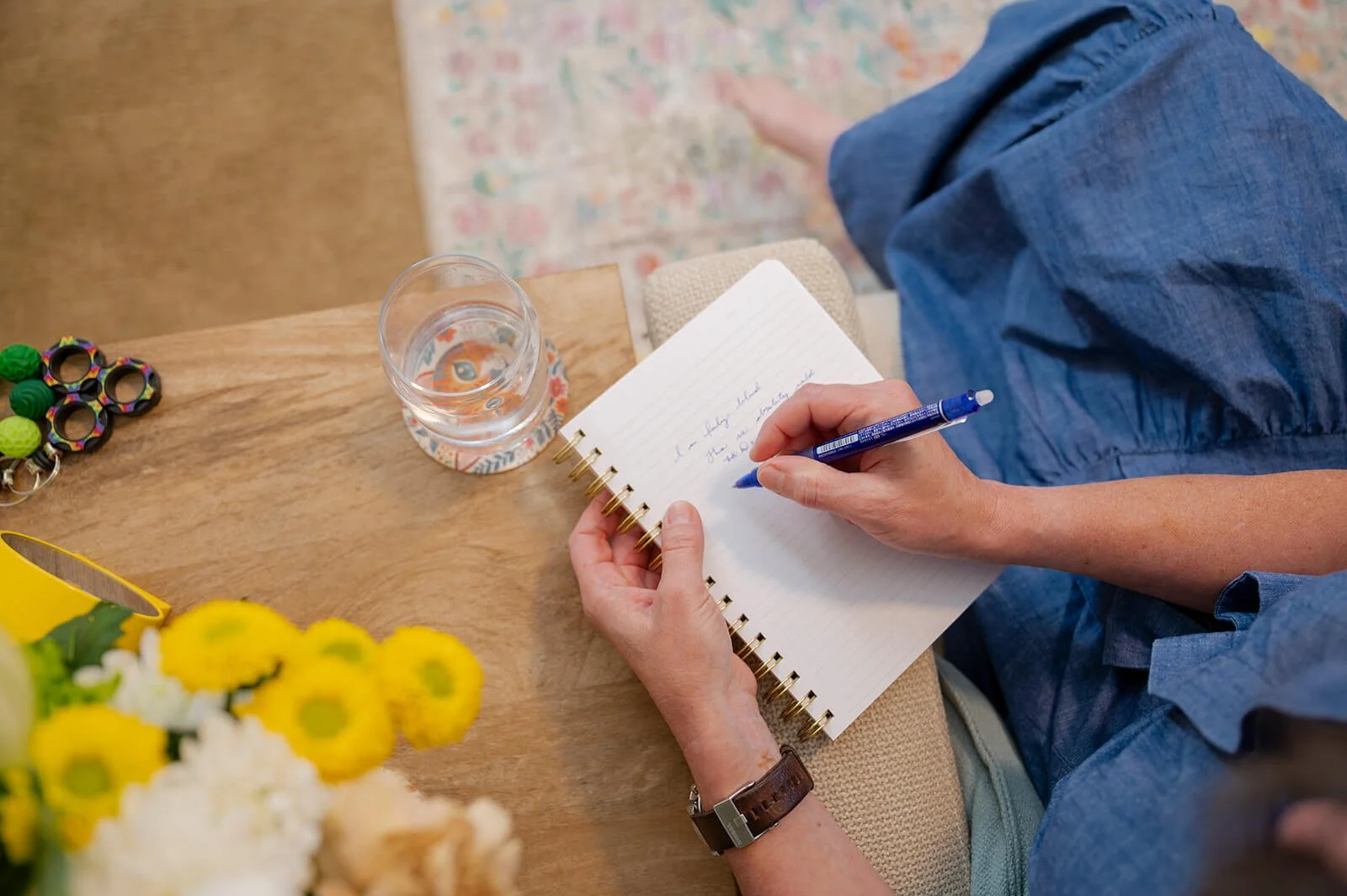 Handwriting notes in a therapy reflection journal beside fresh flowers, representing official session receipts.